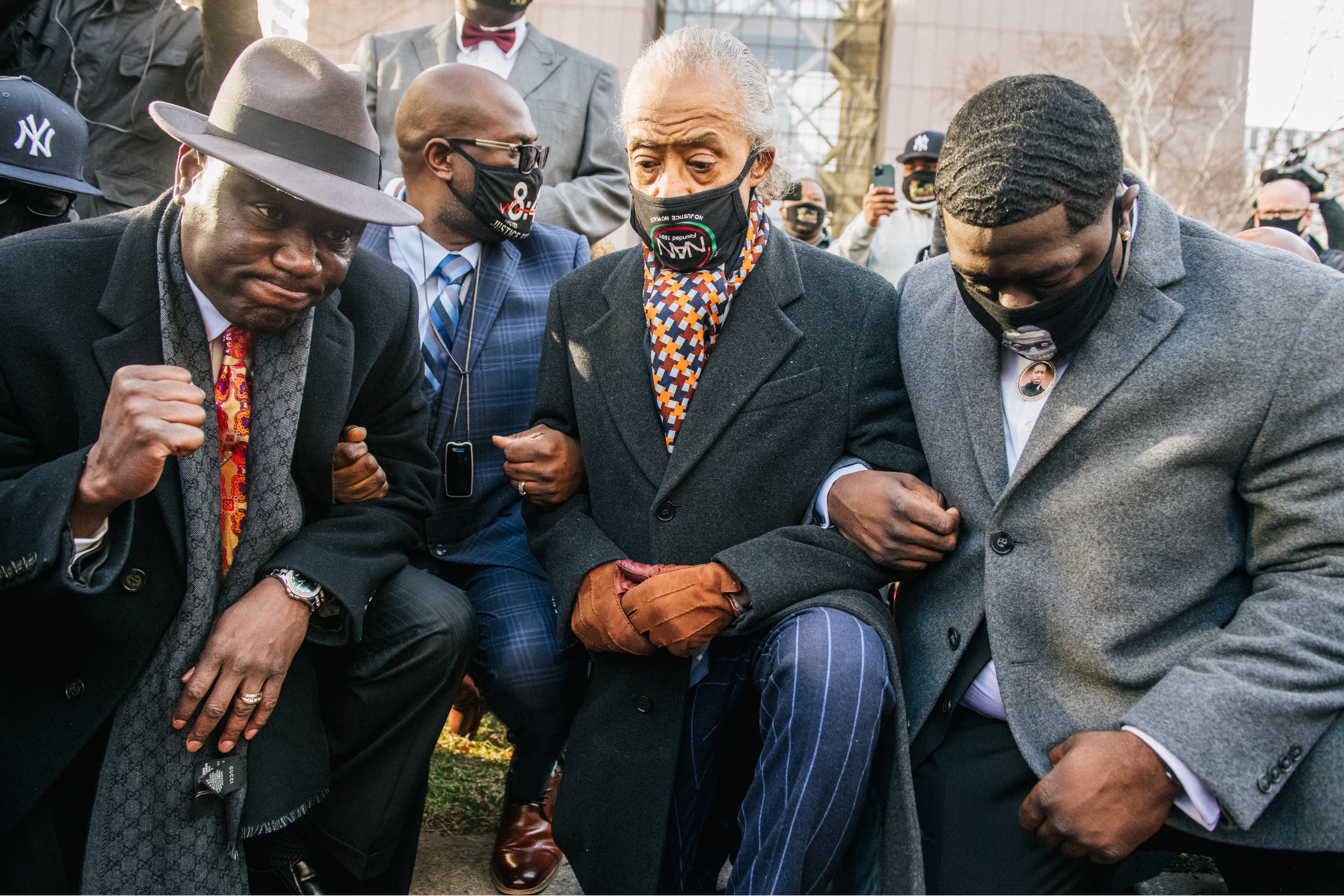 Attorney Ben Crump (L), Rev. Al Sharpton (center) and relatives of George Floyd kneel during a news conference on March 29, 2021 in Minneapolis, Minn., before opening statements in the trial of Derek Chauvin (Brandon Bell—Getty Images)