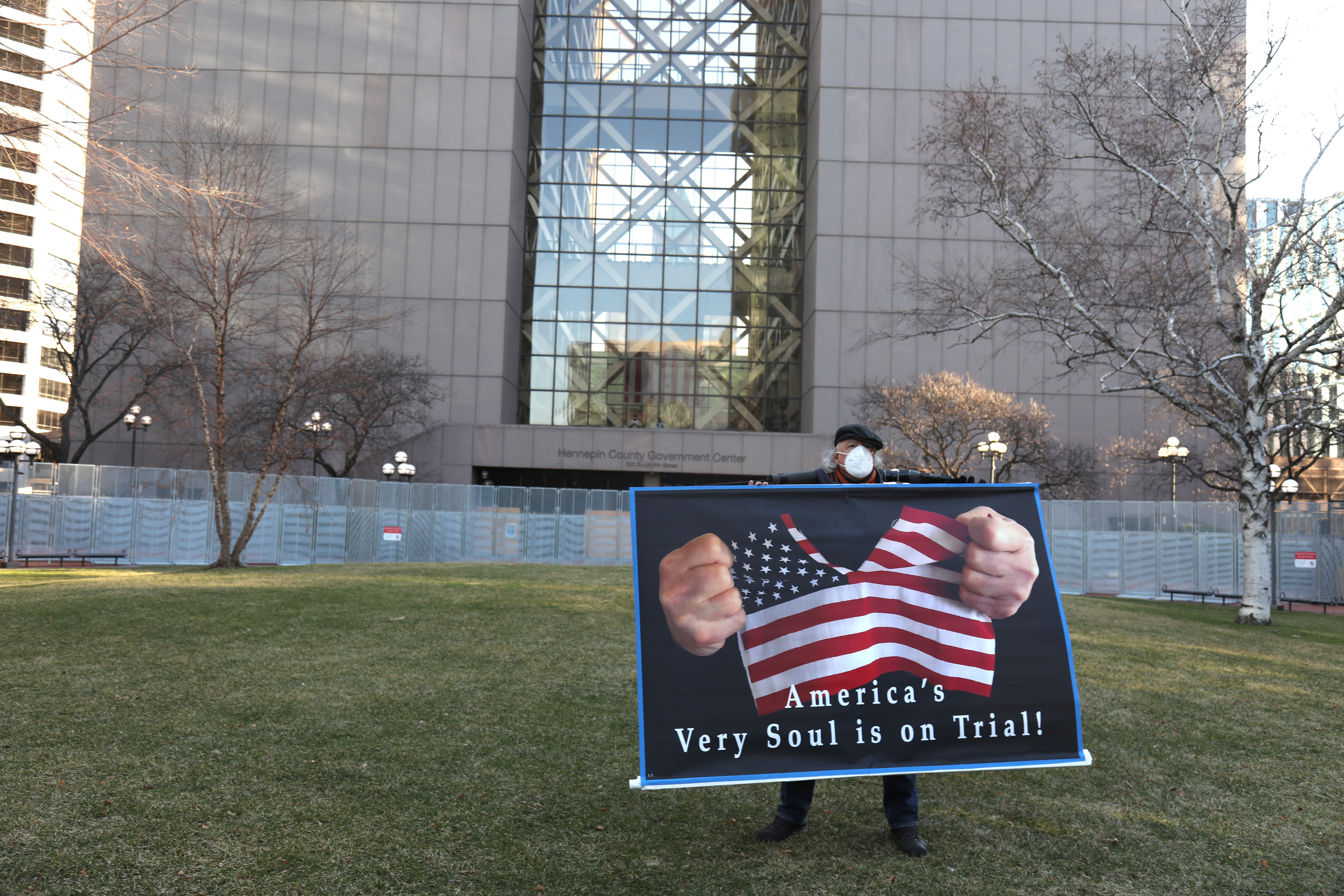 A demonstrator holds a sign outside the Hennepin County Government Center in Minneapolis on Monday, March 29, 2021., as Derek Chauvin's trial began in a courtroom inside (Emilie Richardson—Bloomberg/Getty Images)