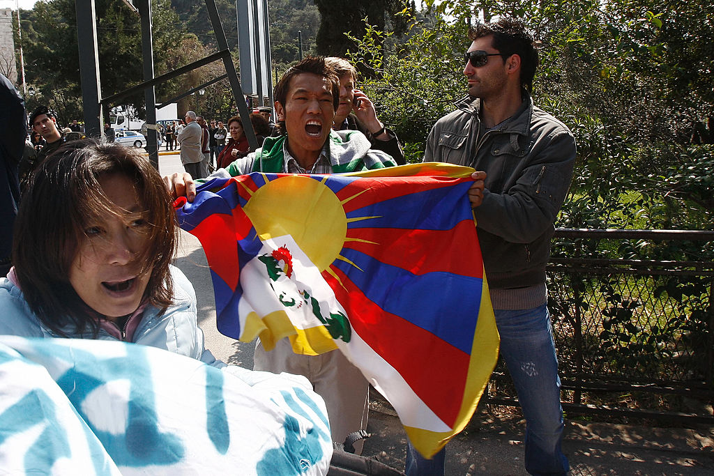 Pro-Tibetan demonstrators, holding a tibetan flag, are detained by plain clothes Greek policemen as they protest and shout anti-Chinese slogans during the handover ceremony of the Olympic flame to China on March 30, 2008 outside the Panathinaiko stadium in Athens. (Kostas Souliotis/AFP via Getty Images)
