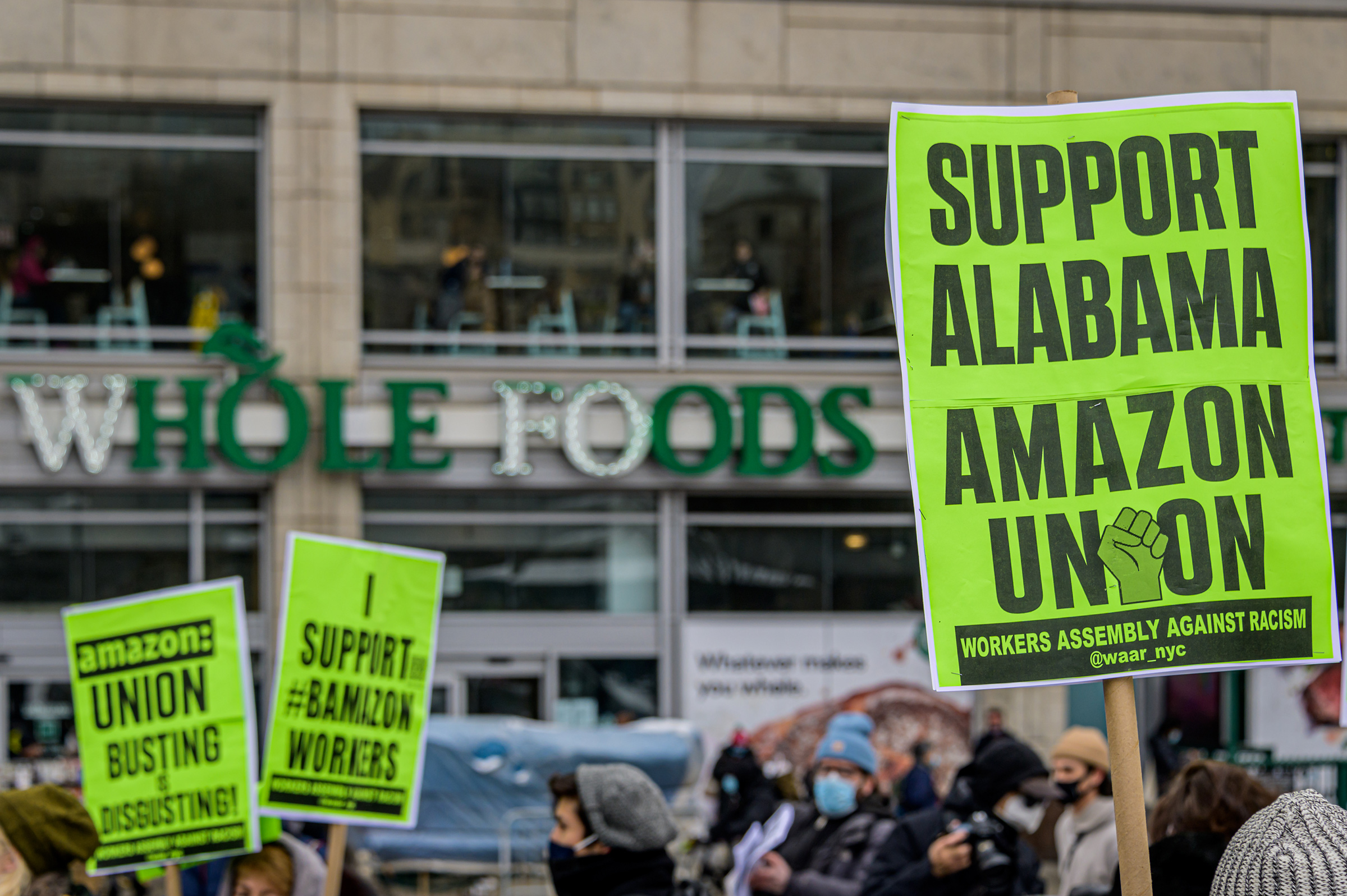 Participants seen holding signs and marching on a picket line at the protest. Members of the Workers Assembly Against Racism gathered across from Jeff Bezos-owned Whole Foods Market in Union Square South for a nation-wide solidarity event with the unionizing Amazon workers in Bessemer, Alabama. (Erik McGregor—LightRocket/Getty Images)