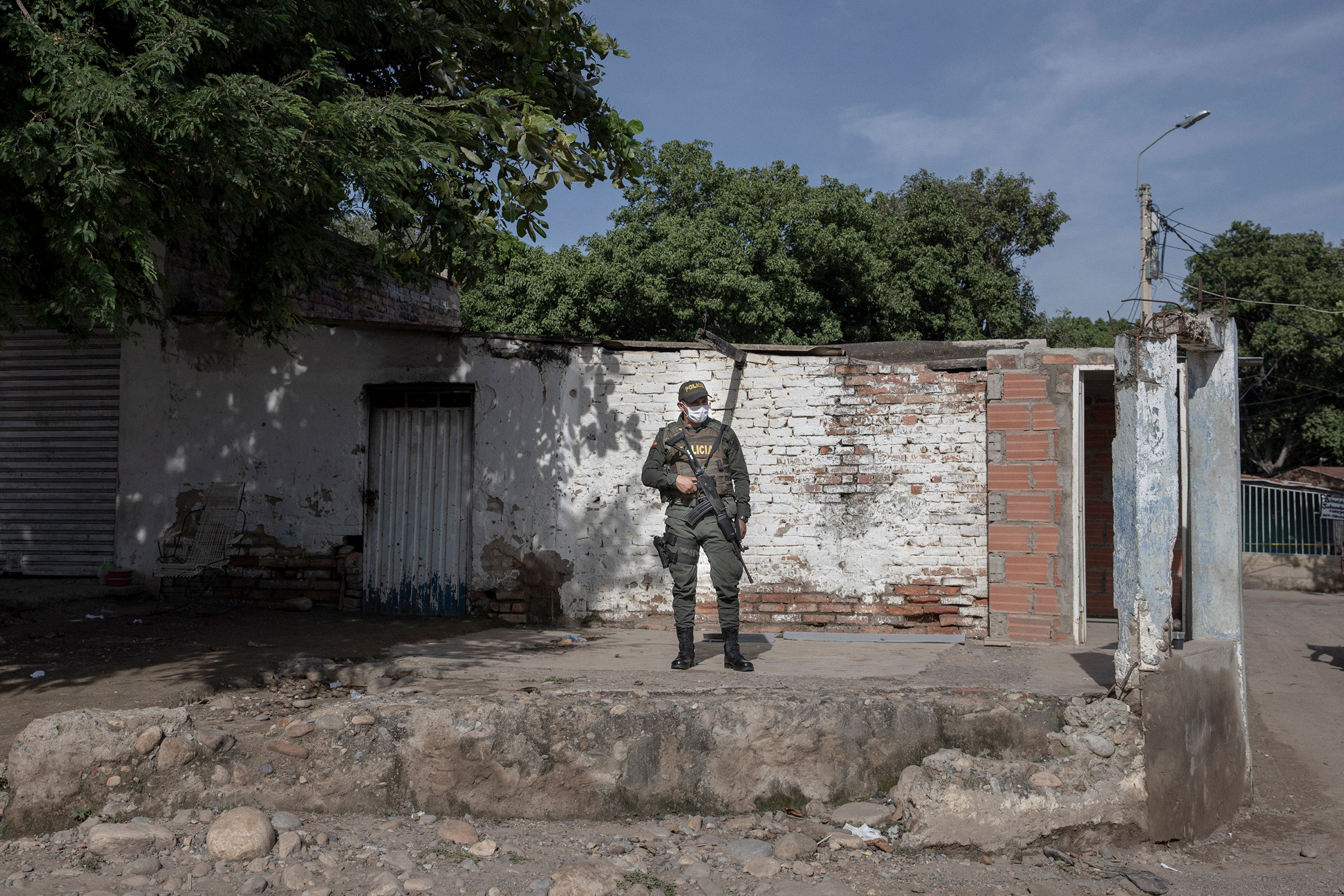 A Colombian police officer stands at the entrance of an illegal border crossing.