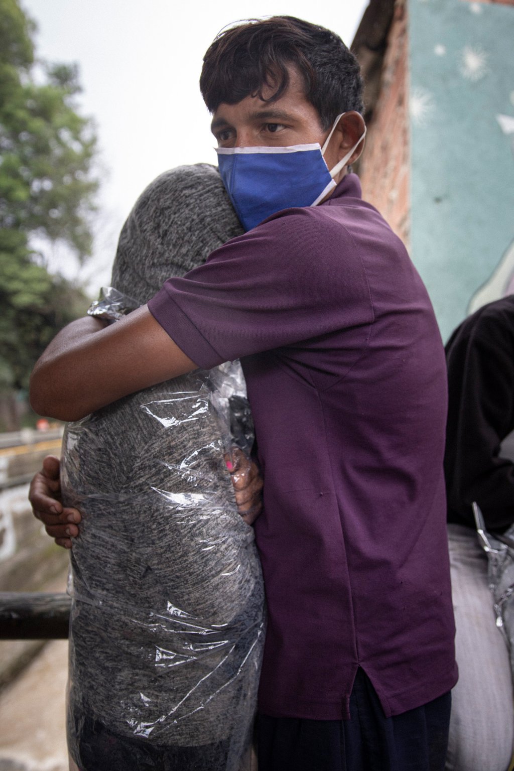 Johnmier Briceño and his girlfriend hug while taking cover from the rain in Pamplona, Colombia.