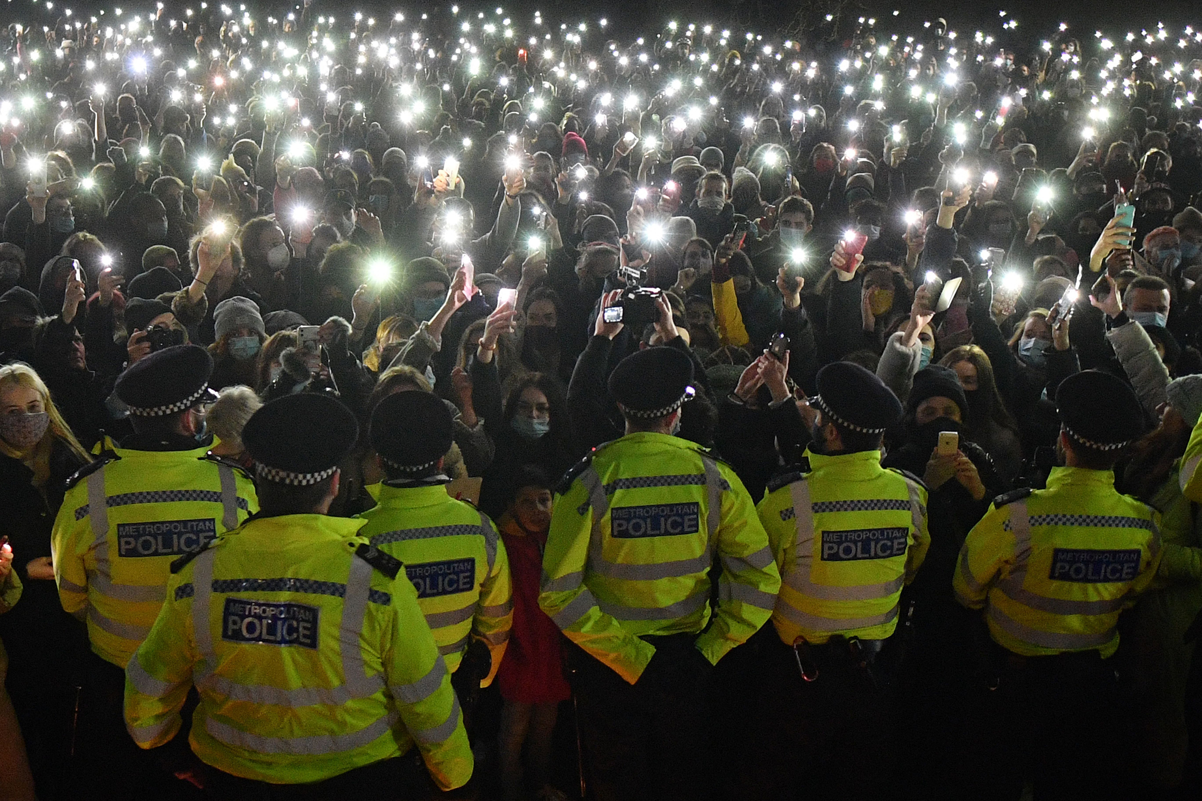 Well-wishers, gathered for a planned vigil for Sarah Everard in Clapham Common, south London, turn on their phone torches as the event was cancelled after police outlawed it due to Covid-19 restrictions on March 13 (Justin Tallis—AFP/Getty Images)