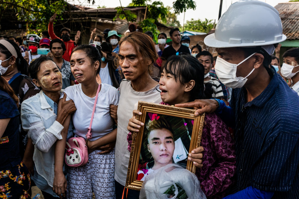 The wife (2nd from left) and a sister (2nd from right) of Chit Min Thu, 25, who was killed in clashes, cry during his funeral at the family's home in Yangon, Myanmar on March 11, 2021. (Getty Images)