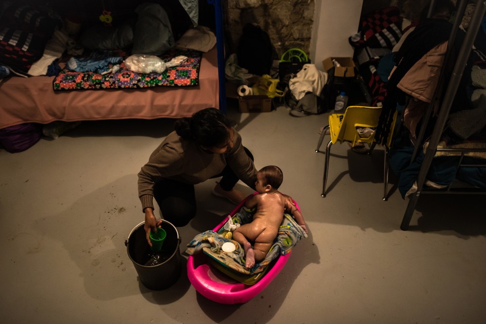 A mother from El Salvador bathes her baby.