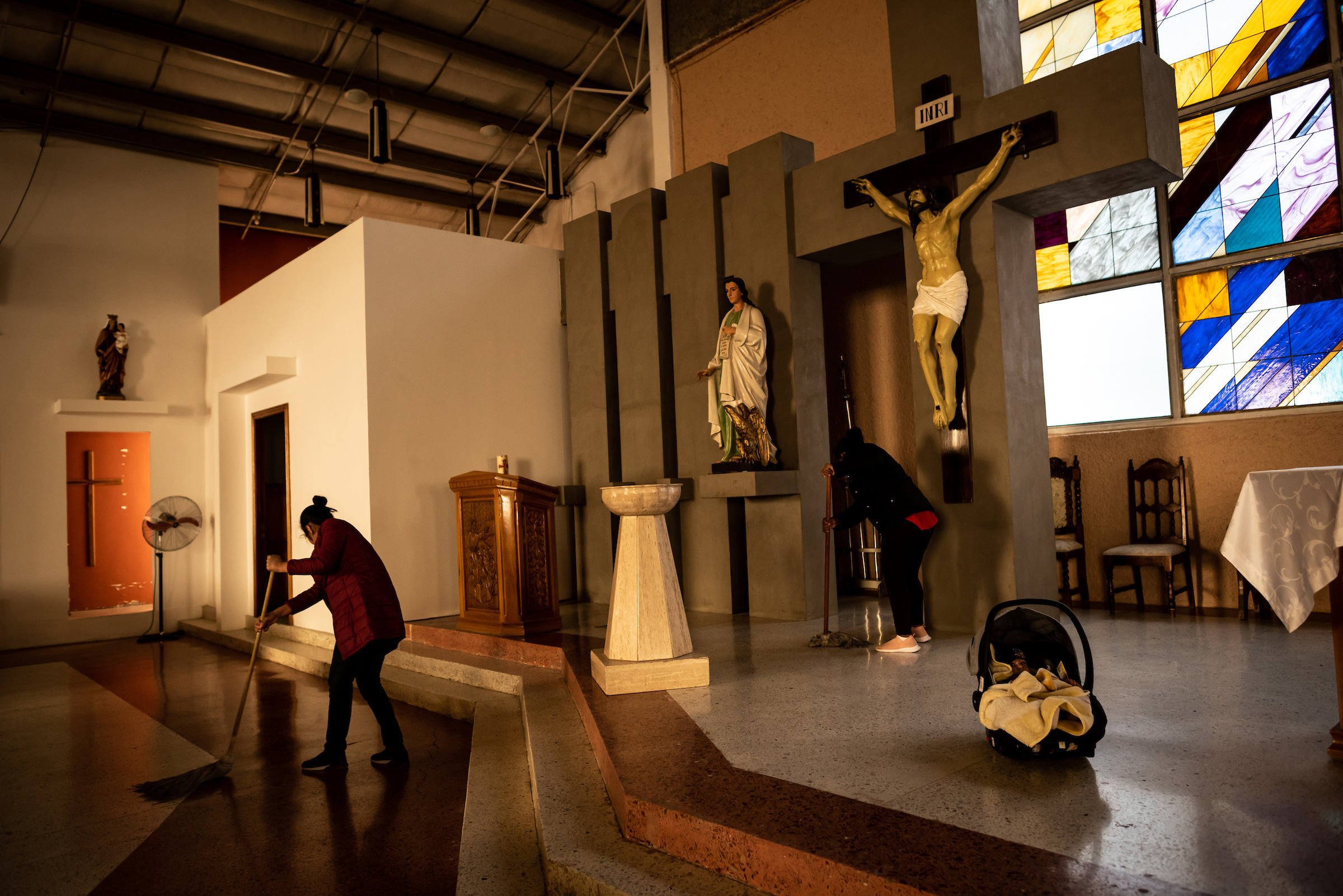 Migrant women mop the sanctuary floors of the San Juan Apóstol Evangelical Parish. The Parish built living quarters on the side of their church to shelter migrant women who are pregnant or who recently gave birth.