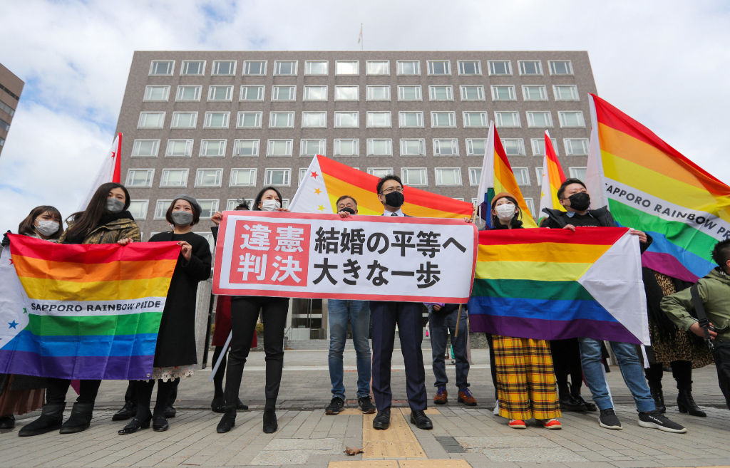 Supporters hold the "unconstitutional decision" flag as they are pleased with the Sapporo District Court's decision that it is unconstitutional to not allow same-sex marriage in Sapporo, Hokkaido prefecture on March 17, 2021. (STR/JIJI PRESS/AFP/ Getty Images)
