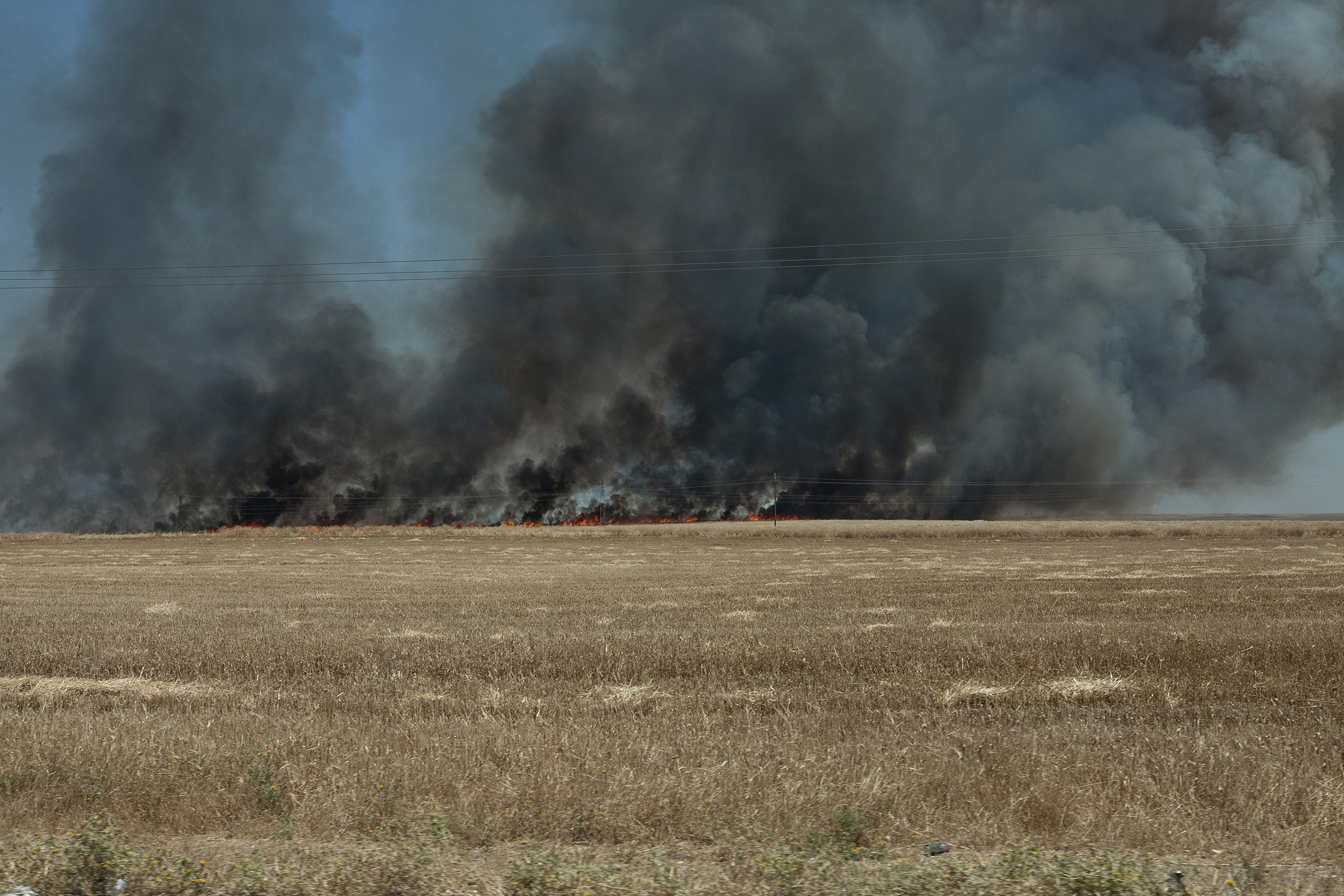 A field burns on the road between Al-Maabadah and Qamishli in June 2019. The dominating rumor among the Kurdish population was the fires were set by ISIS sleeper cells.