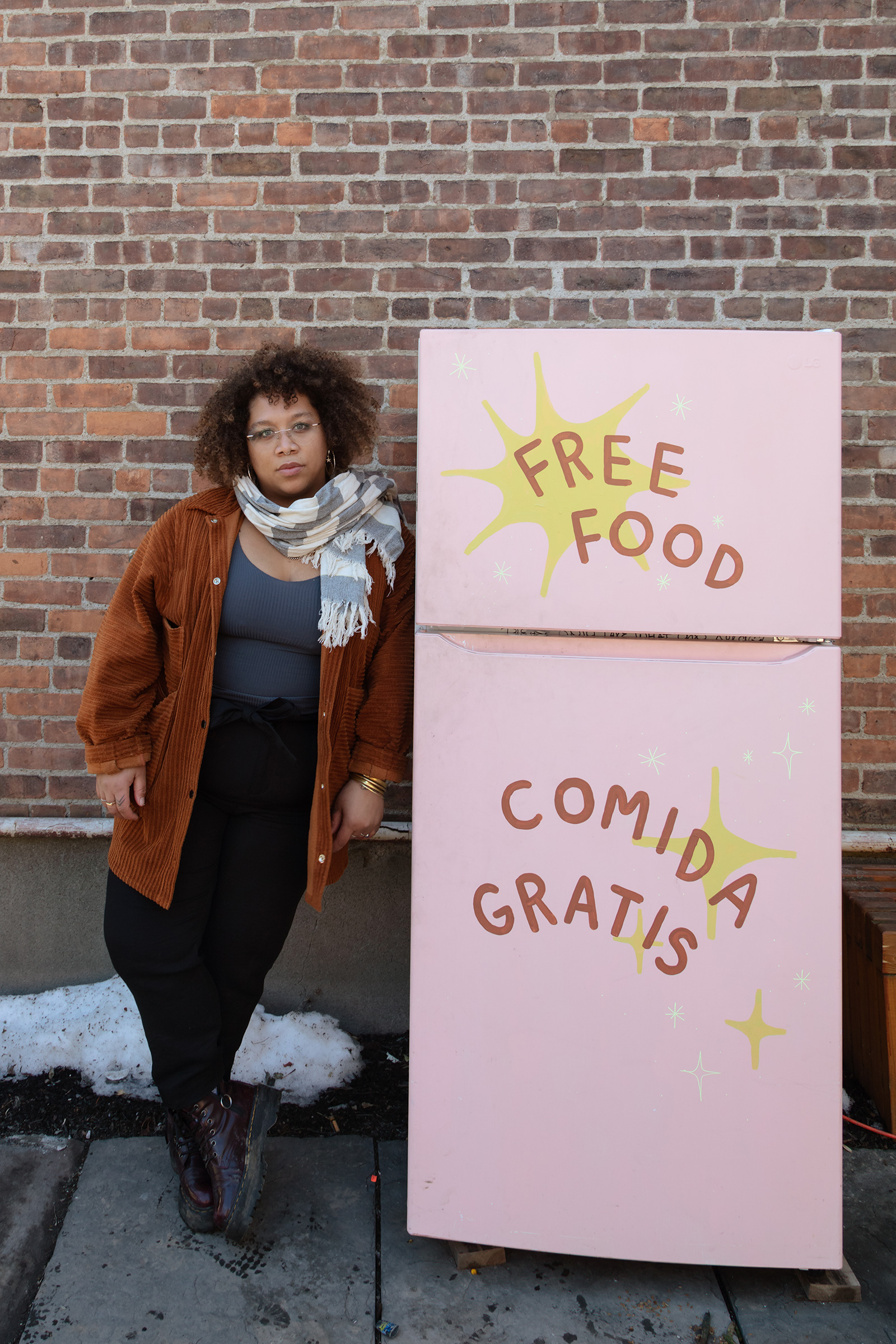 Jammella Anderson next to one of her Albany, N.Y., food fridges. Most share the same inviting verbiage: FREE FOOD. COMIDA GRATIS (Naima Green for TIME)