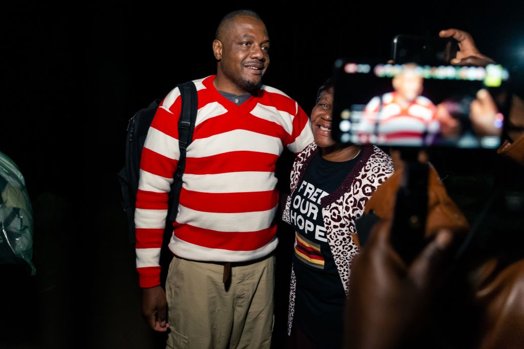 Zimbabwean journalist Hopewell Chin'ono is embraced by a supporter following speaking to the press after his release on bail from Chikurubi Maximum Prison in Harare, on September 2, 2020. (JEKESAI NJIKIZANA/AFP via Getty Images)
