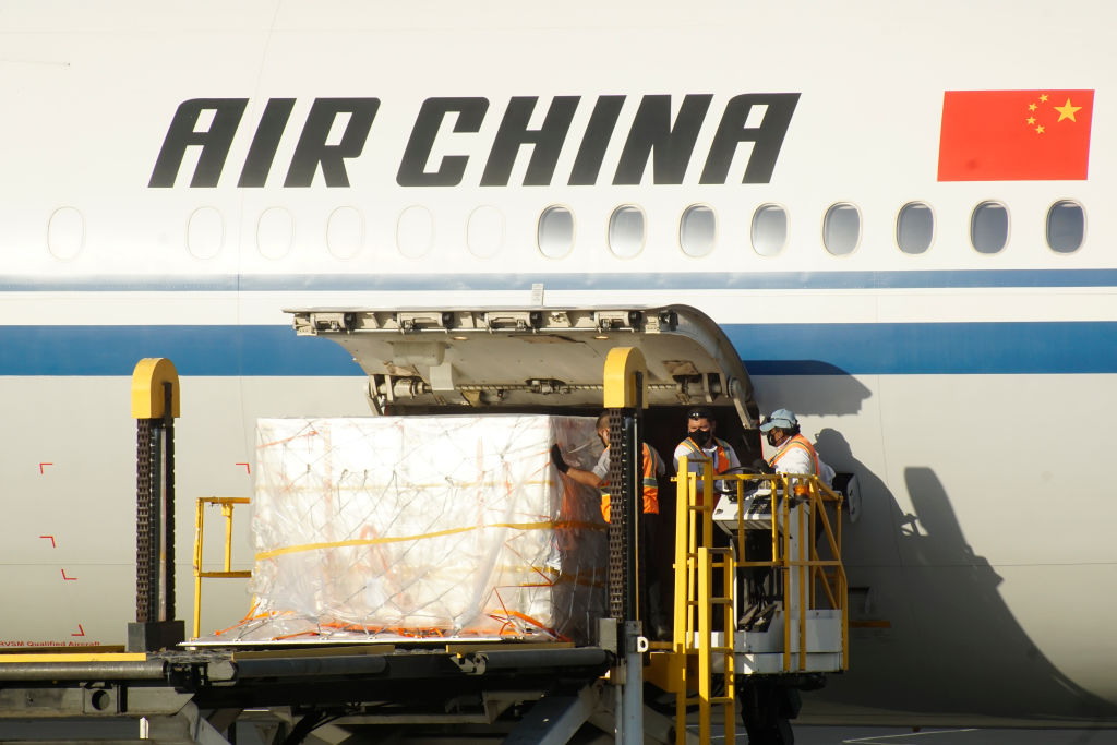 Workers unload vaccine doses from an Air China flight during the arrival of a new batch of Sinovac vaccines against Covid-19 at El Salvador International Airport in La Paz, El Salvador, on March 28, 2021. (Camilo Freedman—APHOTOGRAFIA/Getty Images)