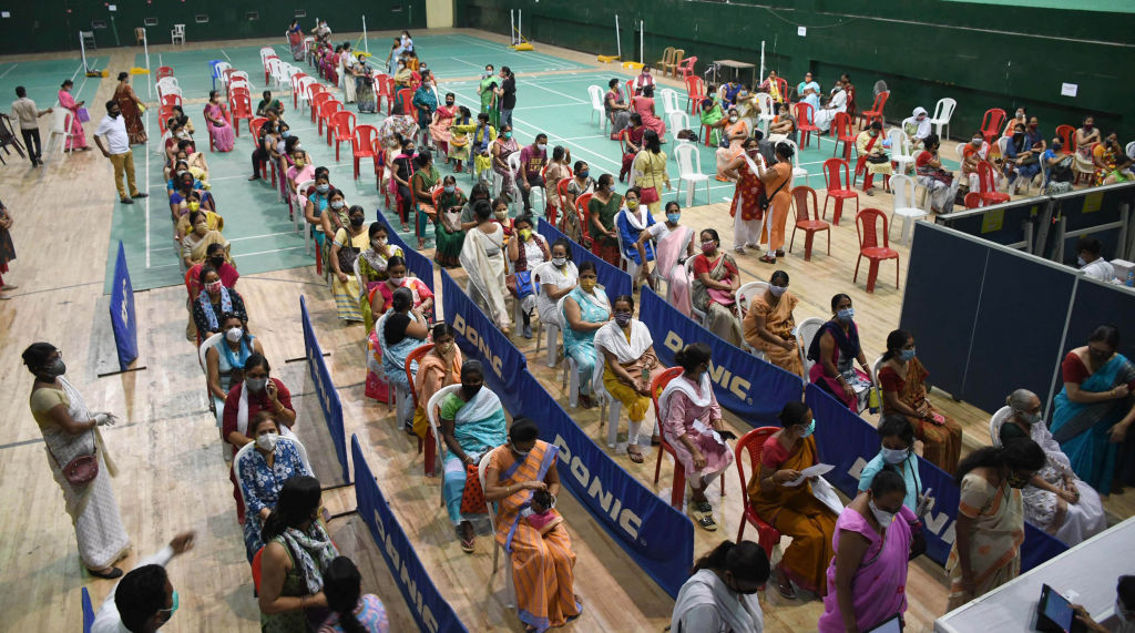 Women line up to receive the COVID-19 vaccine at an indoor stadium in Guwahati, India. (Anuwar Ali Hazarika–Barcroft Media/Getty Images)