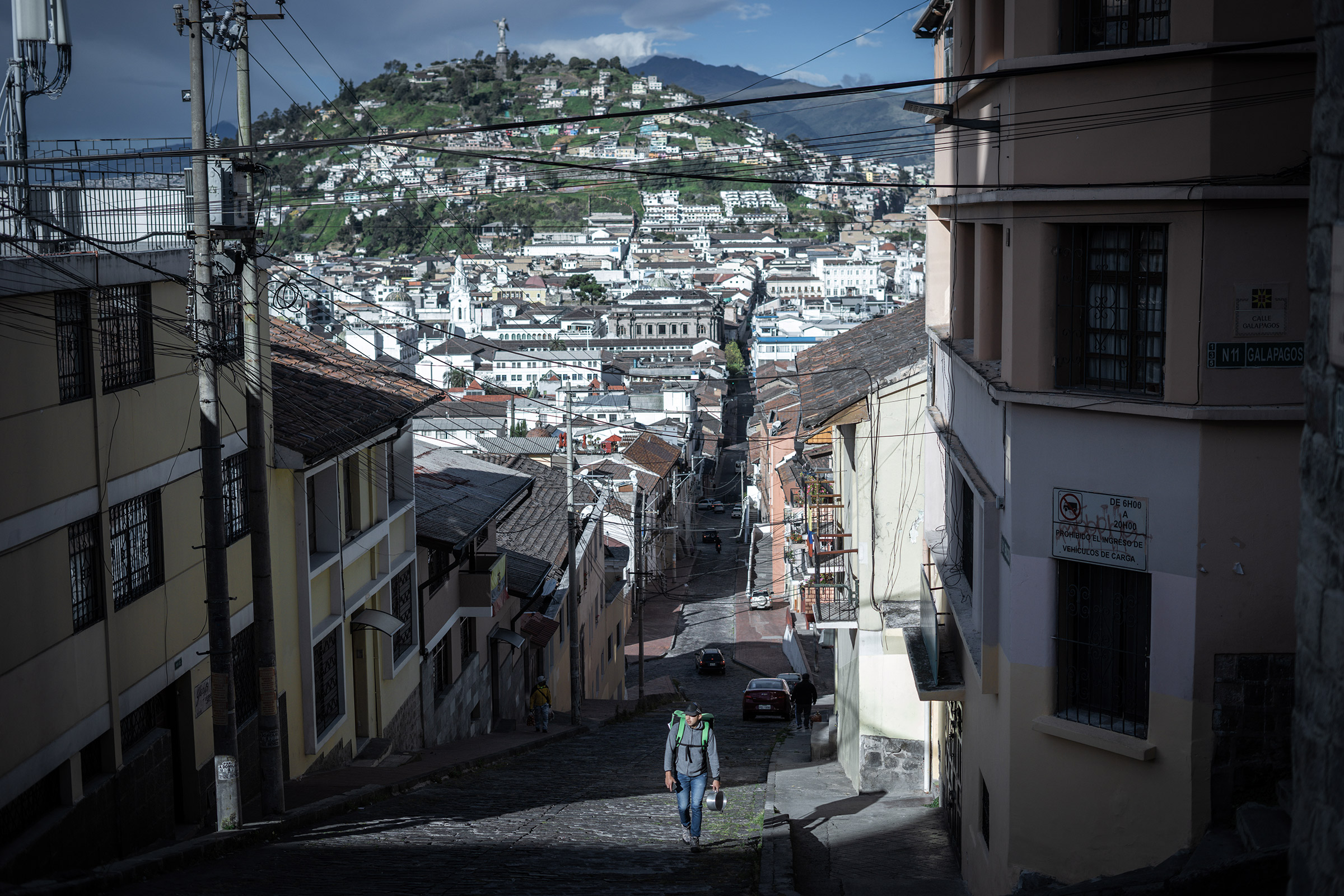 A delivery man walks to a garage he rents in the center of Quito, Ecuador. Many delivery drivers do not own their motorcycles or garages and often rent, leaving them with less profit.