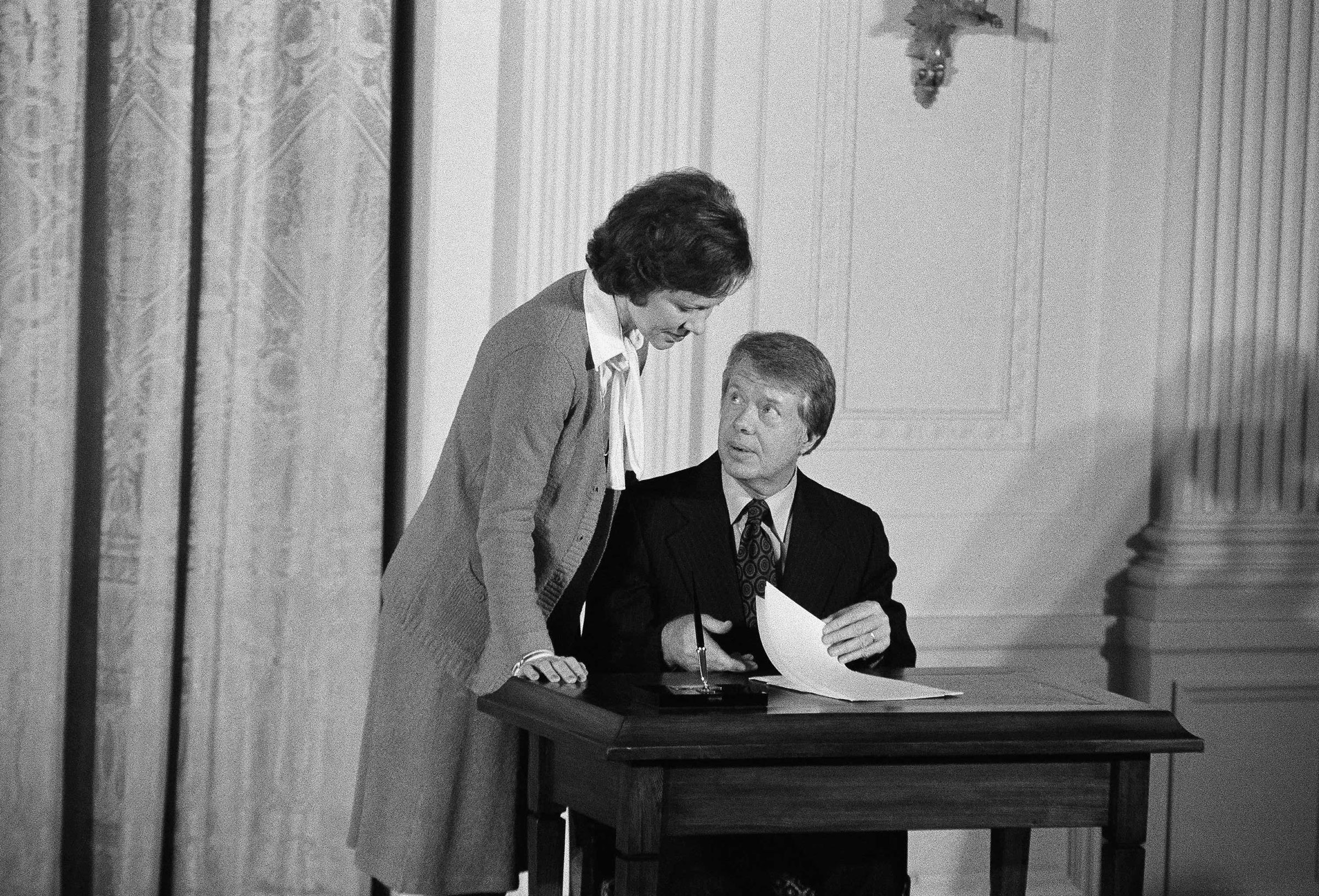 President Jimmy Carter stops to talk with first lady Rosalynn Carter prior to signing an executive order establishing the Presidential Commission on Mental Health at the White House on Feb. 17, 1977.