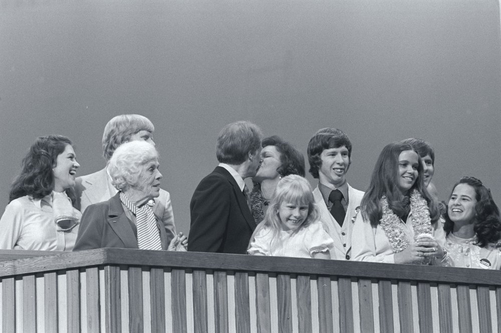 Then presidential nominee Jimmy Carter and Rosalynn Carter share a kiss while standing with their family at the 1976 Democratic National Convention.