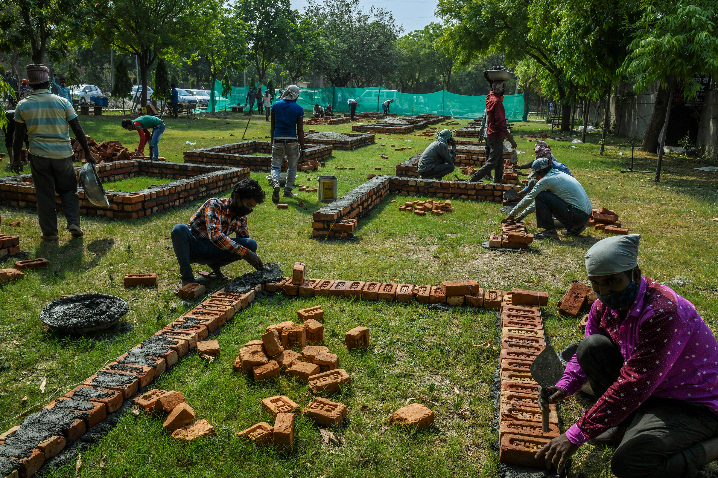 Workers build new platforms to expand a mass cremation site in New Delhi on April 27.