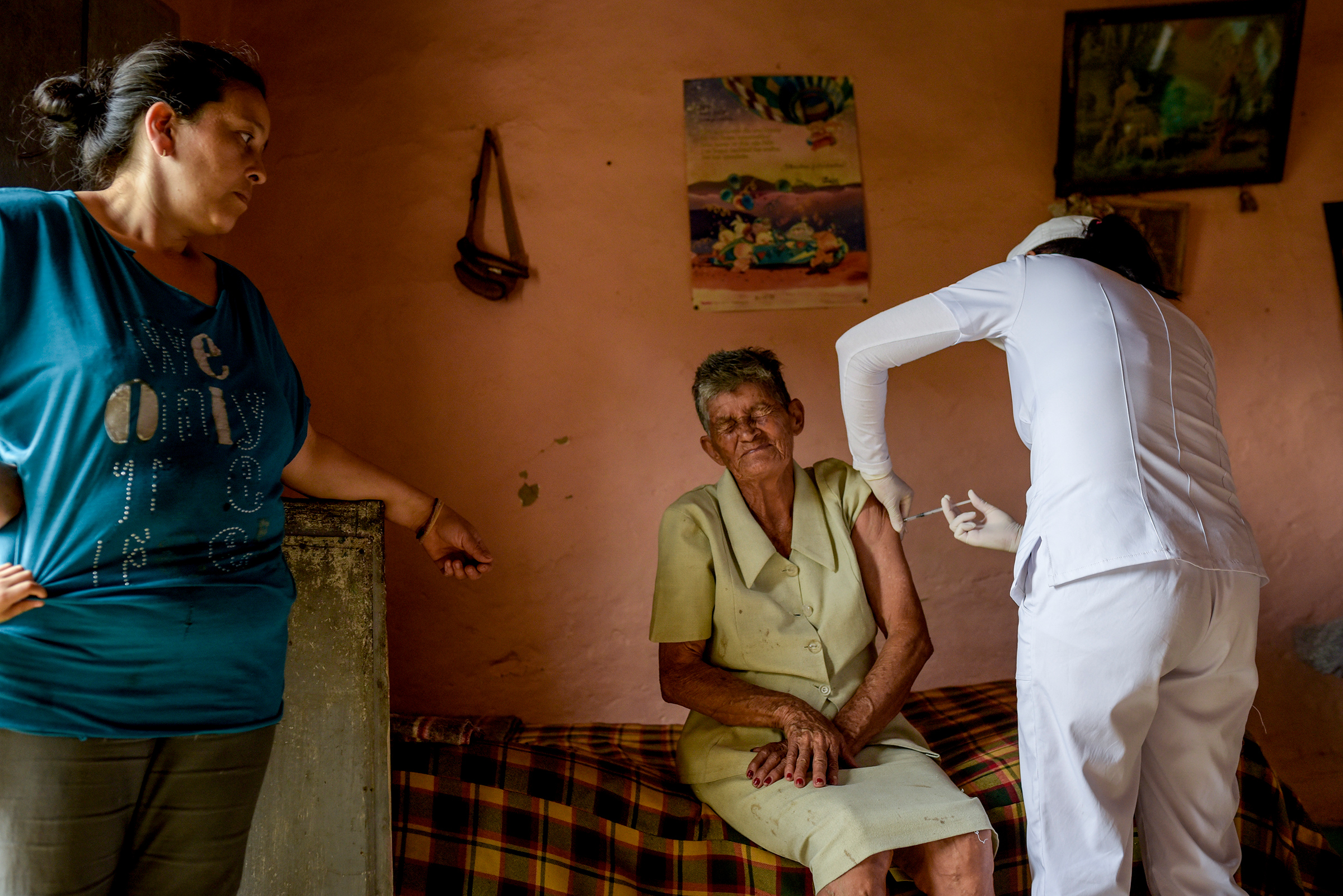 Saturia Campos, 80, receives a dose of the Novavax vaccine as her daughter watches in Chaguaní, Colombia, on April 8, 2021. Vaccination brigades made their way into inhospitable rural areas to administer COVID-19 vaccines to senior citizens. Depending on the distances and difficulty of access, each brigade vaccinates between 12 and 18 people per day. (Mariano Vimos—Getty Images)