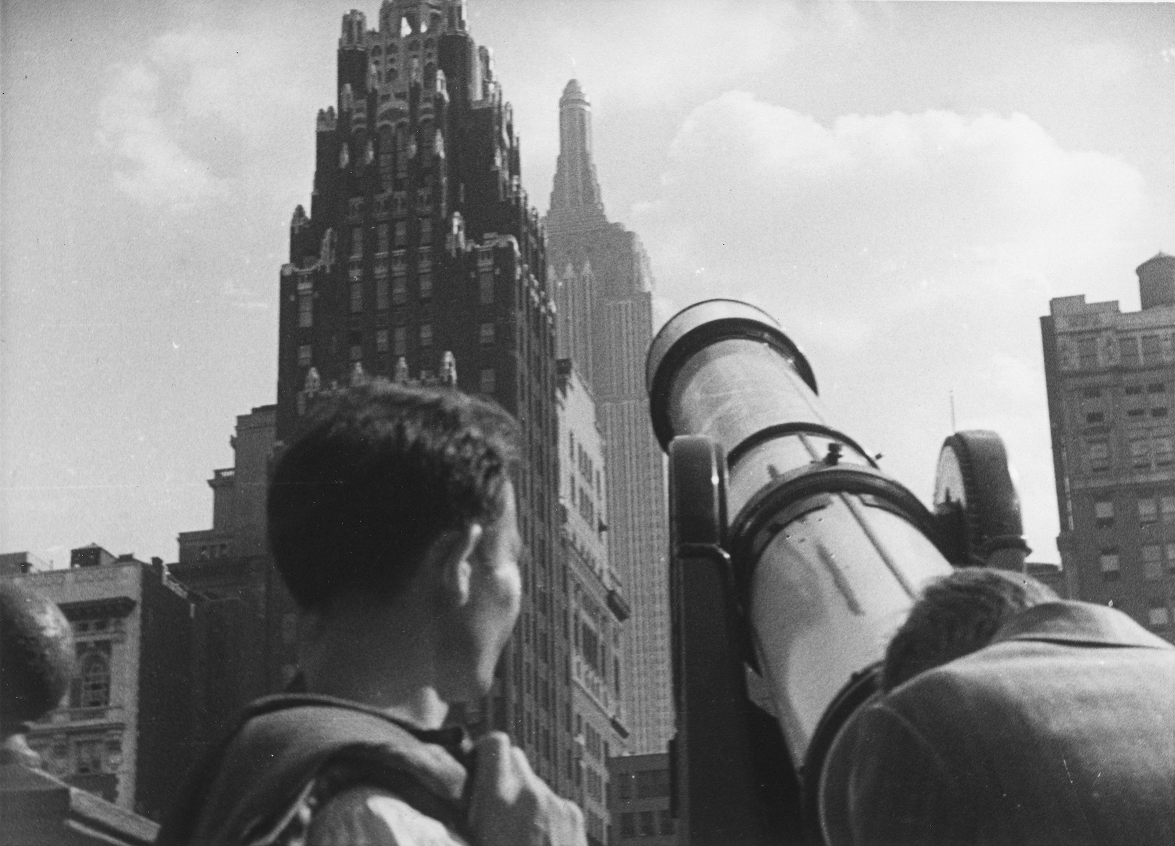 Tourists at Bryant Park looking through a telescope toward American Radiator Building and the  Empire State Building, New York City, circa 1930s. (Irving Browning—The New York Historical Society/Getty Images)