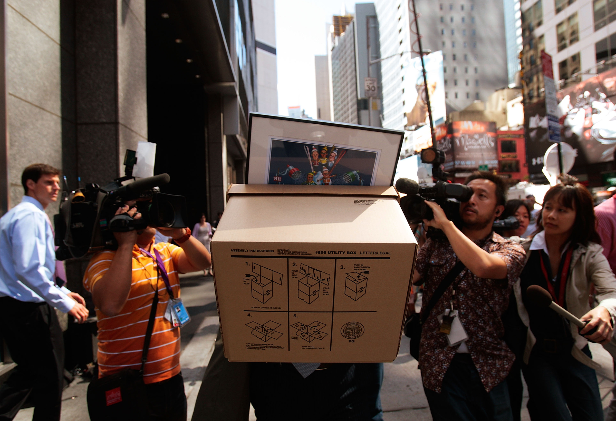 An employee of Lehman Brothers Holdings Inc. carries a box out of the company's headquarters as he is followed by the media Sept. 15, 2008 in New York City.