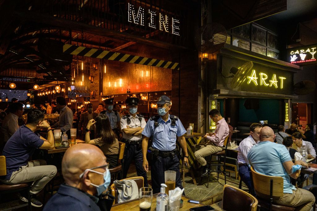 Food and Environmental Hygiene Department officers and police leave after inspecting the license of a restaurant and bar after it reopened, in Lan Kwai Fong, a popular drinking area in Hong Kong on April 29, 2021. (Anthony Wallace&mdash;AFP/Getty Images)