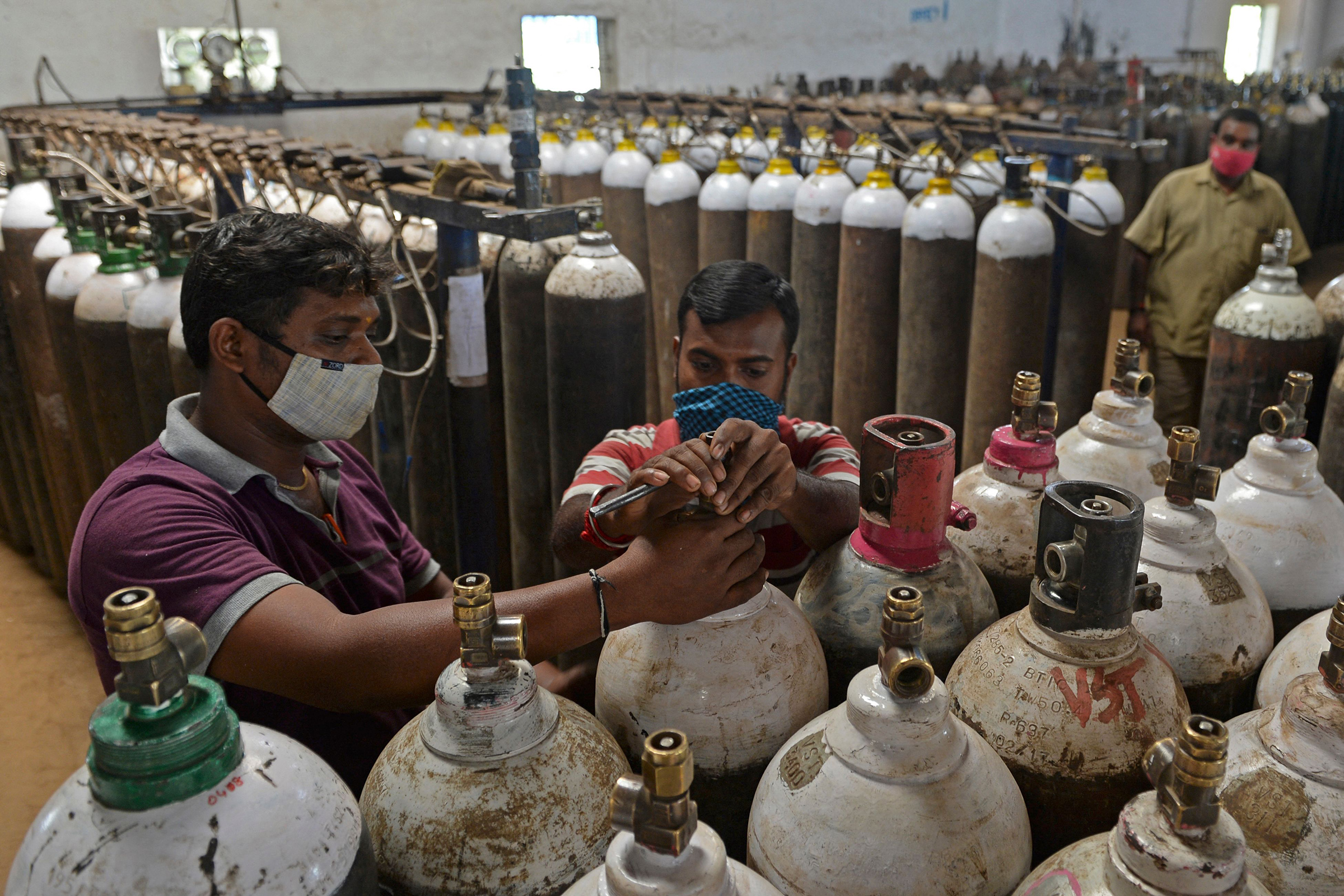 At a facility on the outskirts of Chennai on April 24, workers check medical oxygen cylinders that will be transported to hospitals. (Arun Sankar—AFP/Getty Images)