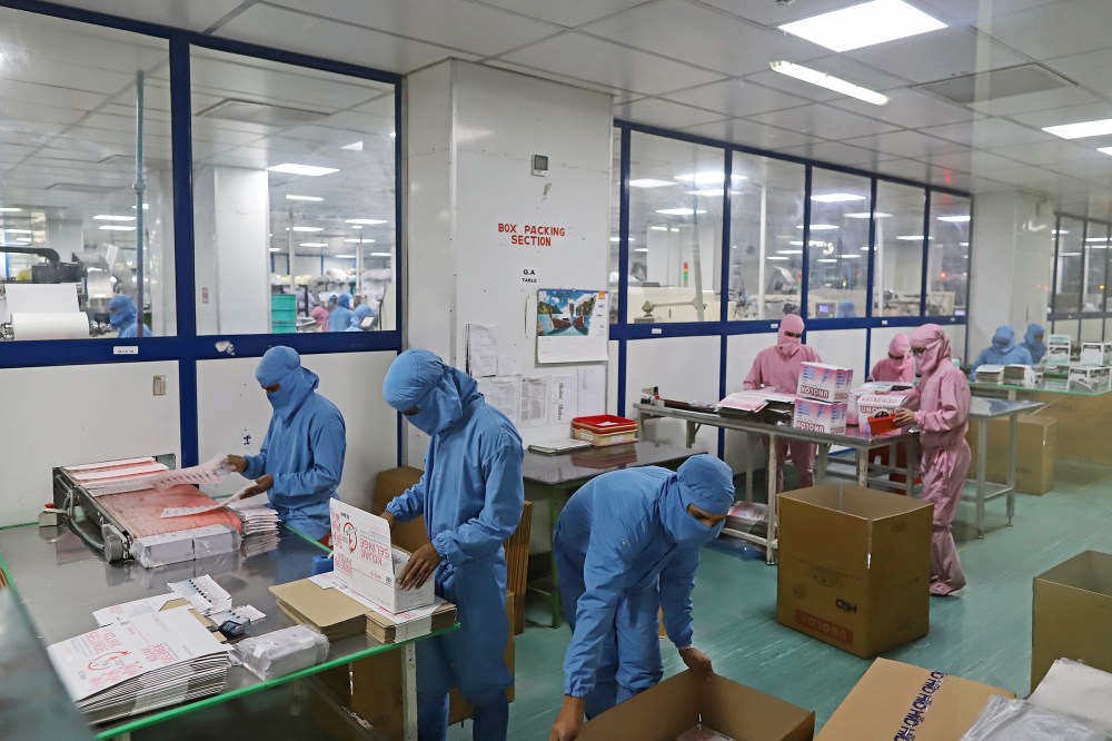 Employees pack boxes of syringes on the production line at the Hindustan Syringes and Medical Devices Ltd. facility in Faridabad, Haryana, India, on March 11, 2021.