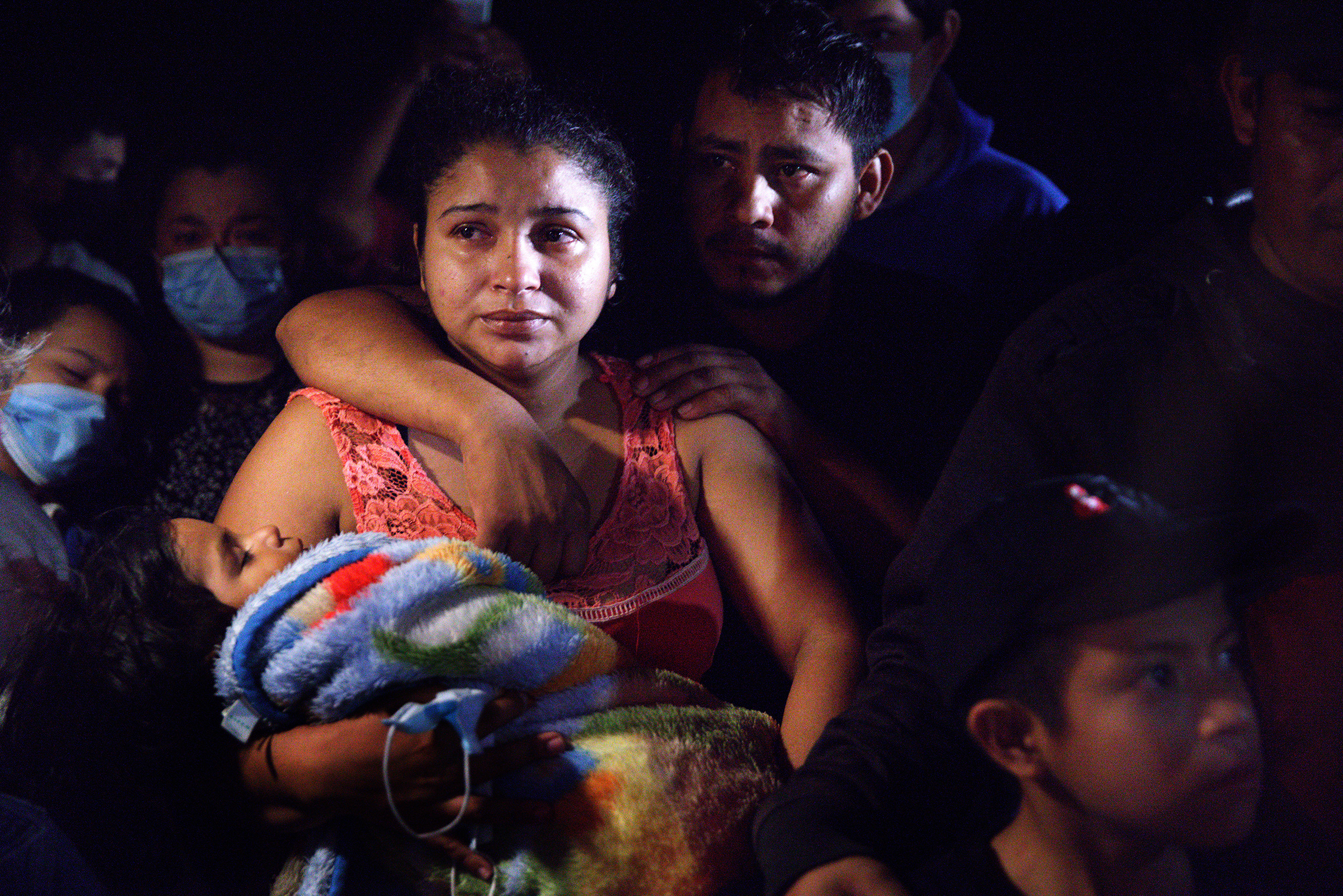 Honduran parents hold their sleeping boy after crossing the Rio Grande from Mexico in Roma, Texas, on April 15, 2021. (John Moore—Getty Images)