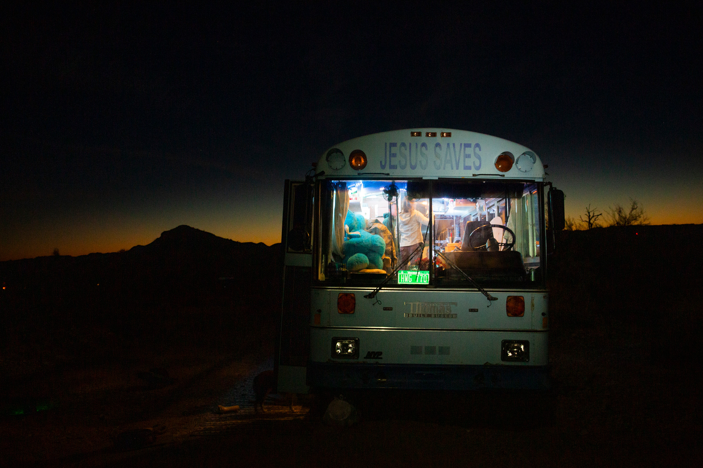 Paula and Max’s ‘Jesus Saves’ bus provides warmth on cold desert nights outside Lake Havasu City, Az., on Feb. 23. Paula was raised Jewish and does not identify as Christian; she found the retired Baptist school bus in San Diego last year and it fit within her budget. (Nina Riggio for TIME)