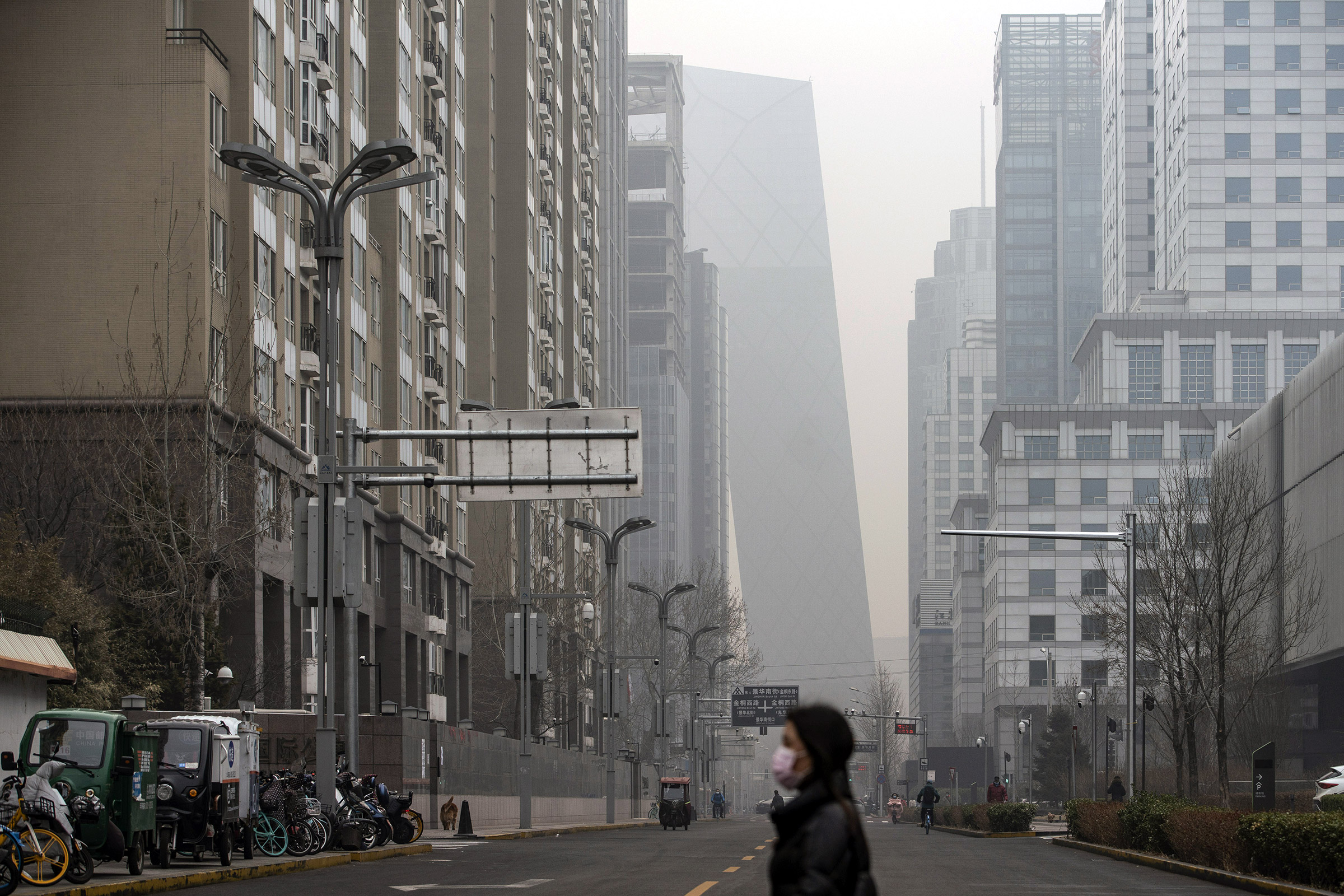 A pedestrian walks in Beijing, shrouded in smog, on March 5, 2021.
