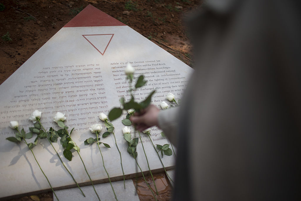 A man lays a white rose at a memorial inaugurated to lesbian, gay, bisexual and transgender victims of the Holocaust on Jan. 10, 2014 in Tel Aviv, Israel. (Uriel Sinai—Getty Images)