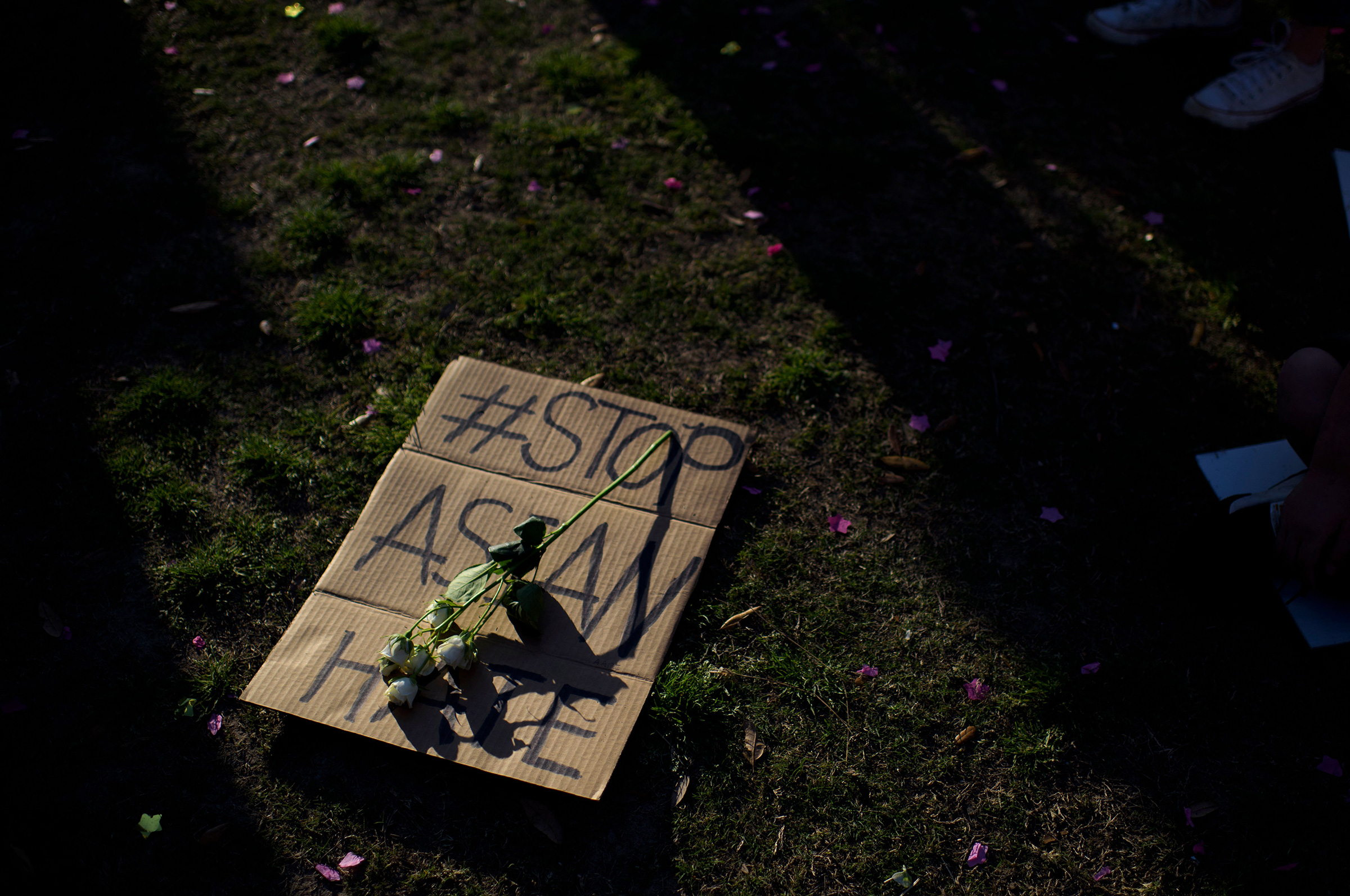 A sign is laid on the grass during a Stop Asian Hate rally in Houston on March 20, 2021. (Mark Felix—AFP/Getty Images)