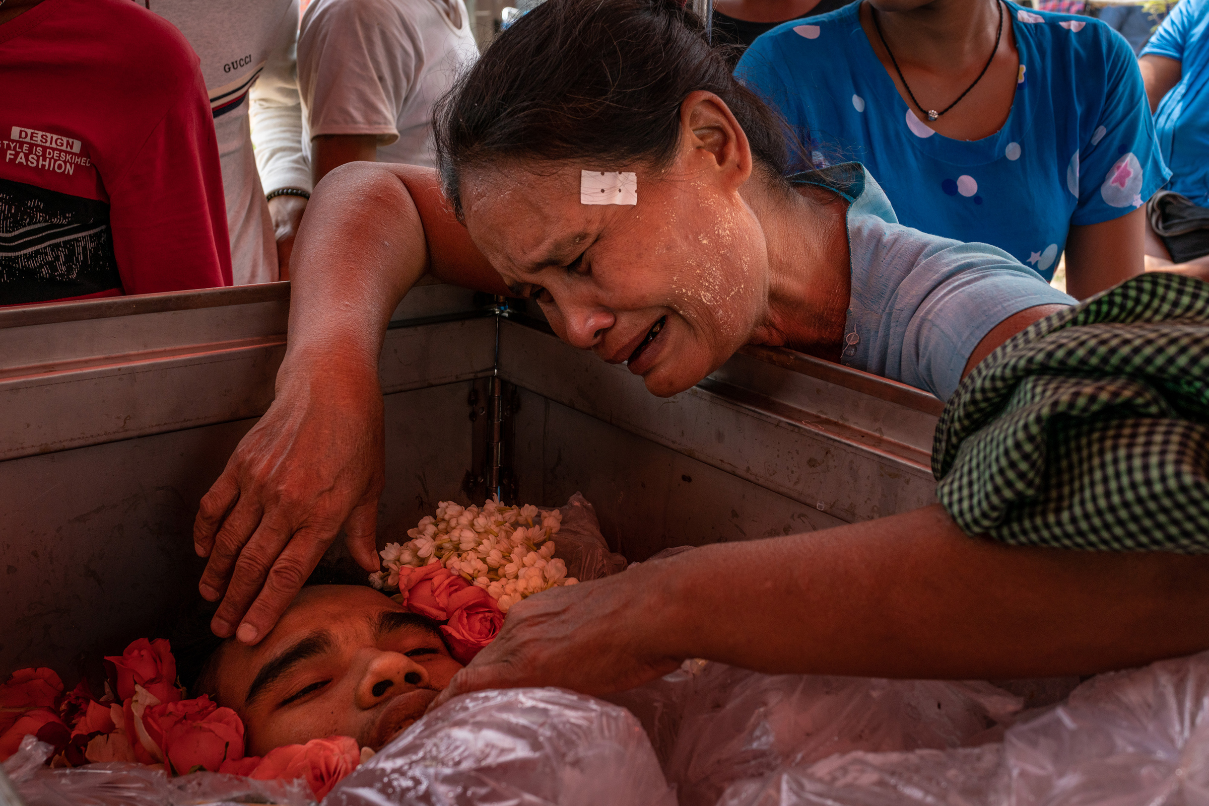 The mother of Aung Zay Min, a 20-year-old who was shot and killed by security forces, mourns over his body at his funeral in Dala township, outside Yangon, Myanmar, on March 27, 2021. (Getty Images)