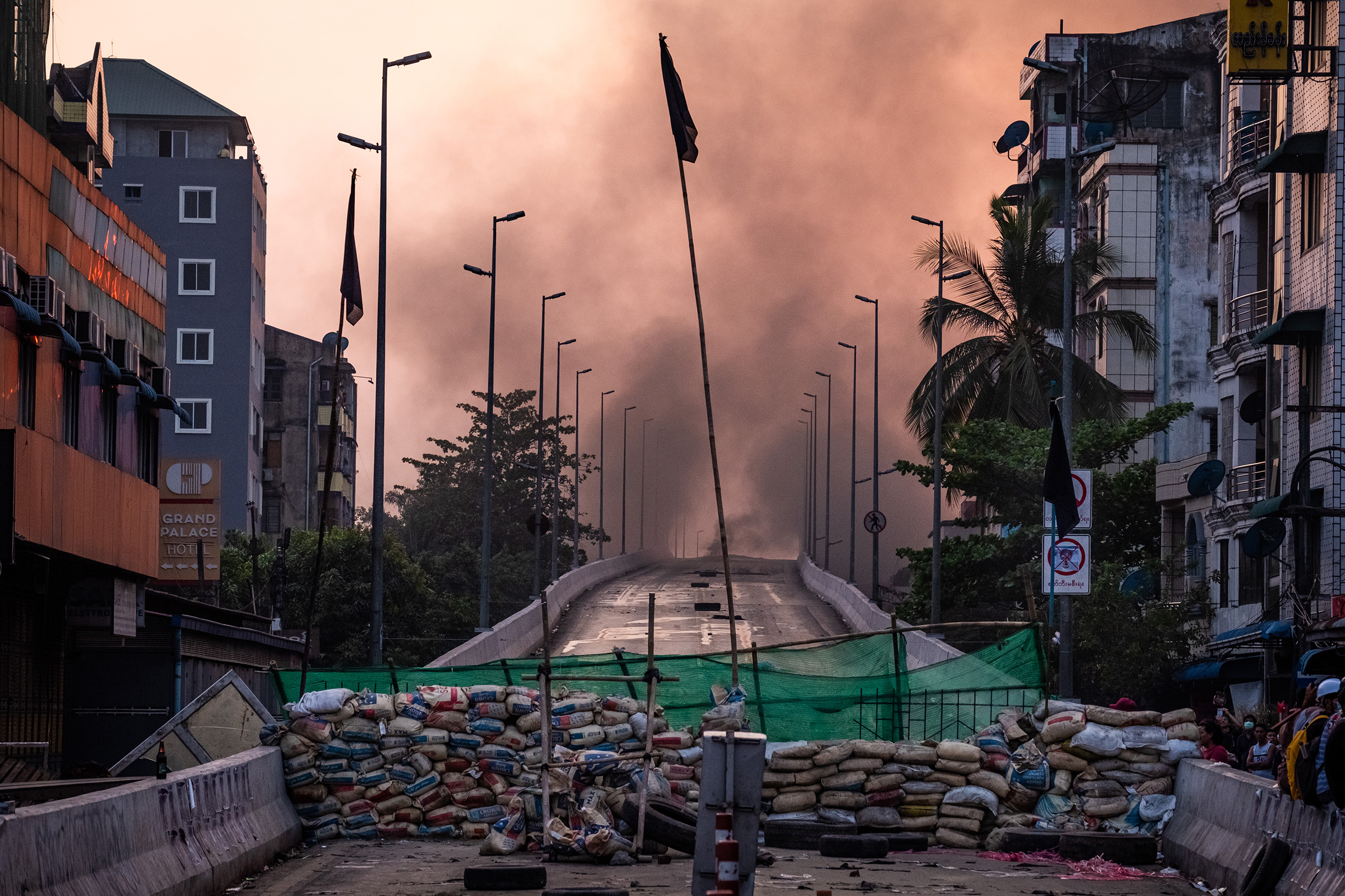 Smoke rises from tires burning near a barricade erected by protesters to stop government forces from crossing a bridge in Yangon on March 16, 2021.