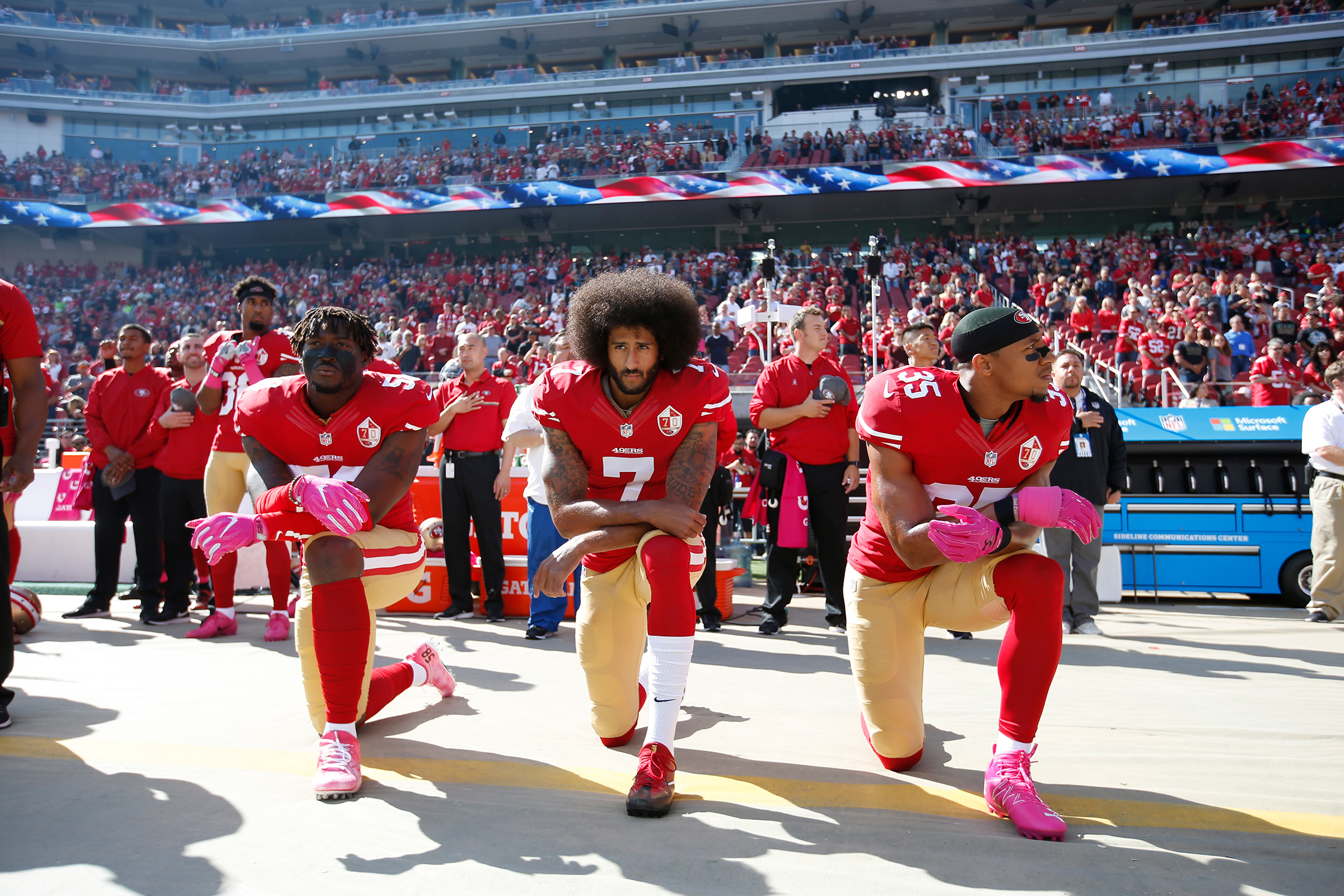 Colin Kaepernick, with teammates Eli Harold and Eric Reid of the San Francisco 49ers, kneel for the anthem prior to the game against the Tampa Bay Buccaneers at Levi Stadium in Santa Clara, Calif. on Oct. 23, 2016. (Michael Zagaris—San Francisco 49ers/Getty Images)