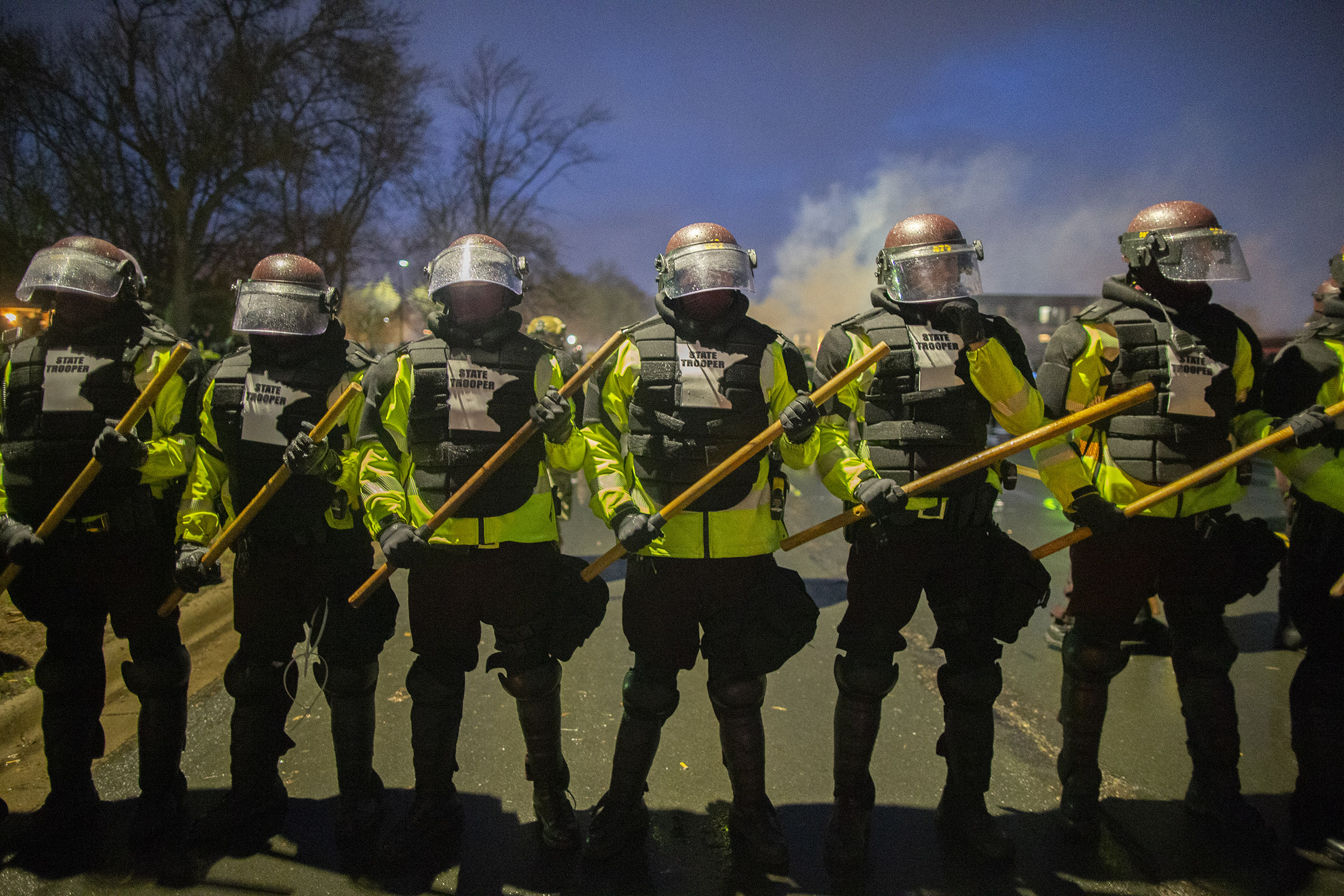 Tear gas rises from behind a line of Minnesota State Troopers as they block the road from anyone going back towards the Brooklyn Center police station where people protesting the police killing of Daunte Wright in Brooklyn Center, Minnesota, U.S., on April 13, 2021. (Christopher Mark Juhn—Anadolu Agency/Getty Images)