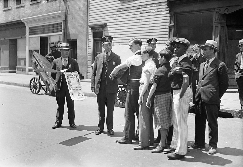 Health officer Jones questions persons before permitting them to pass the quarantine barriers that have been placed at Barclay Street in Newark, N.J., in 1931 to check the spread of smallpox. All entering or leaving must show a vaccination not more than five days old. (Bettmann Archive/Getty Images)