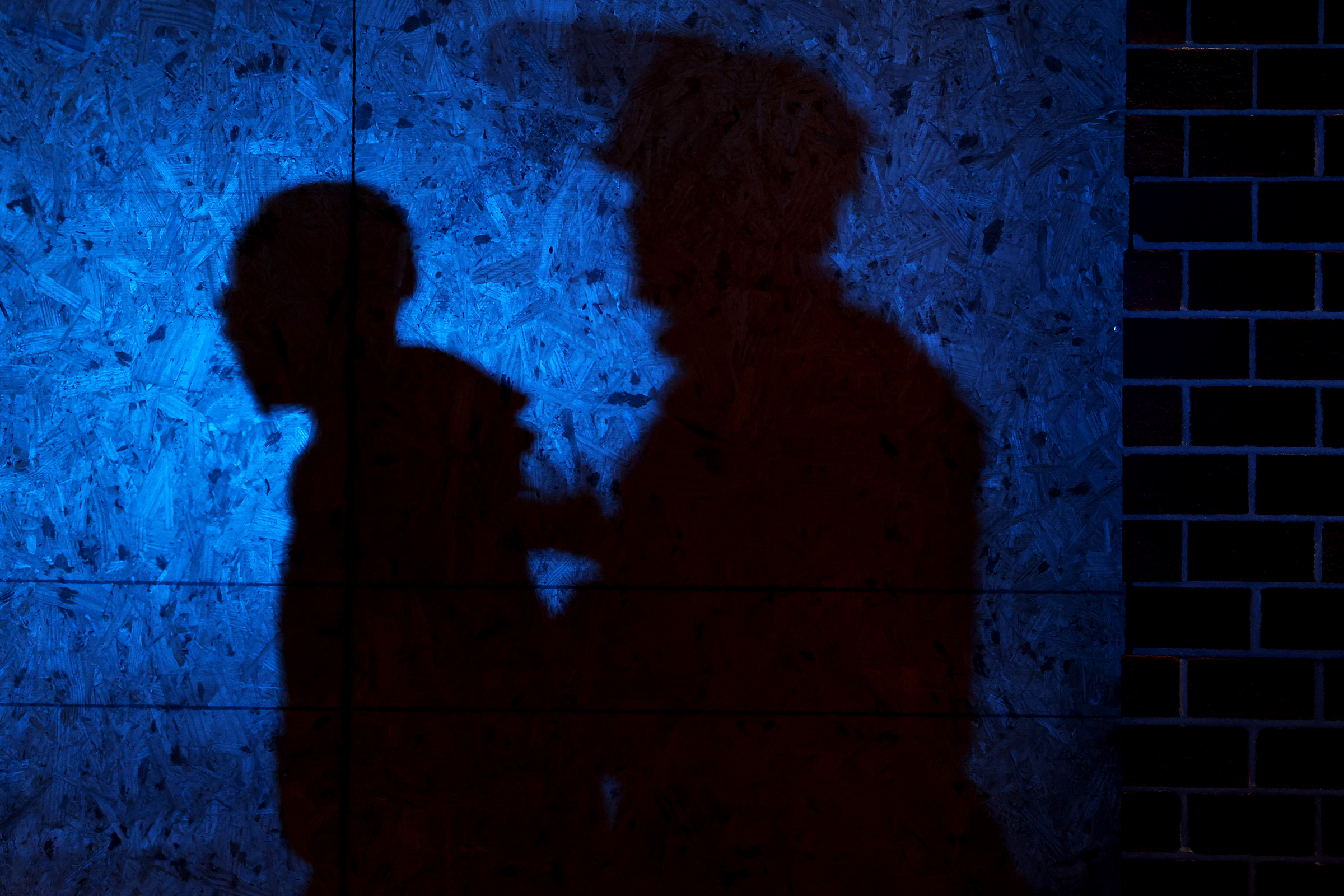 The shadow of a Louisville Police officers arresting a demonstrator is seen on a wall on September 23, 2020 in Louisville, Kentucky. A Kentucky grand jury indicted one police officer involved in the shooting of Breonna Taylor with three counts of wanton endangerment. (Michael M. Santiago—Getty Images)