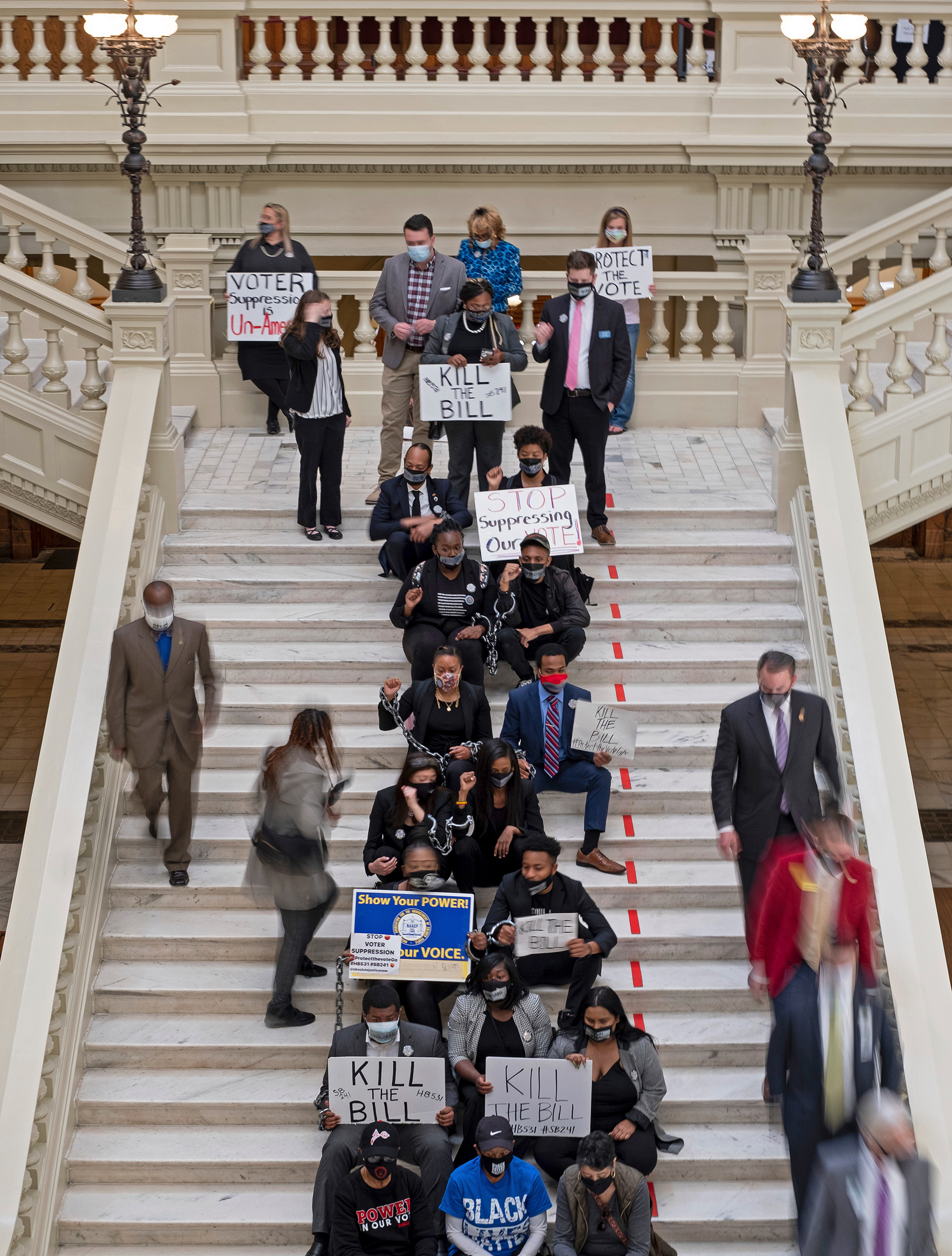 Protesters opposed to changes in Georgia's voting laws sit on the steps inside the State Capitol in Atlanta, Ga., as the Legislature breaks for lunch Monday, March 8, 2021, in Atlanta. (Ben Gray—AP)