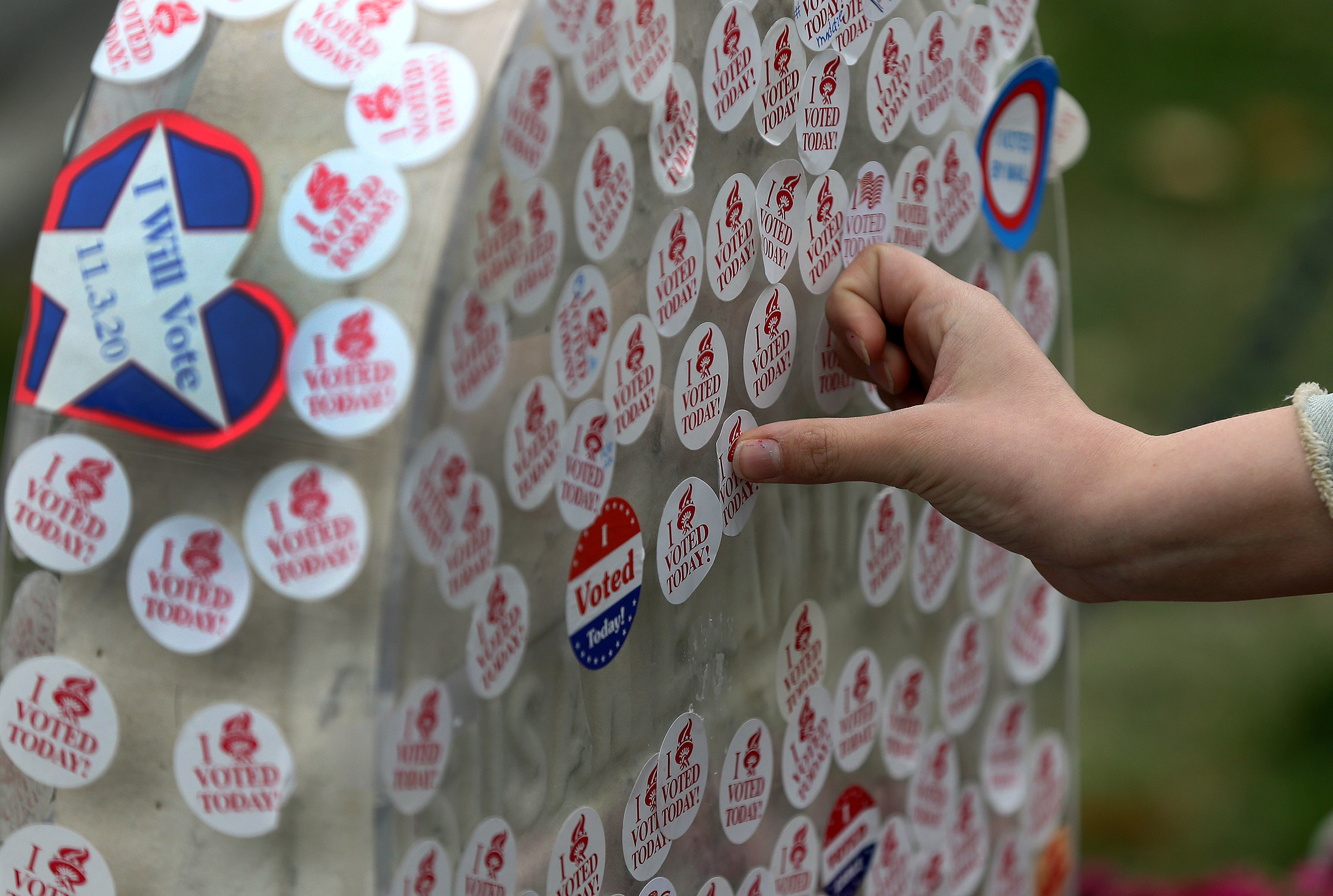In an Election Day tradition, a visitor places their "I Voted" sticker on the gravestone of Susan B. Anthony in Rochester, NY on Nov. 3, 2020. (Jamie Germano—USA Today/Reuters)