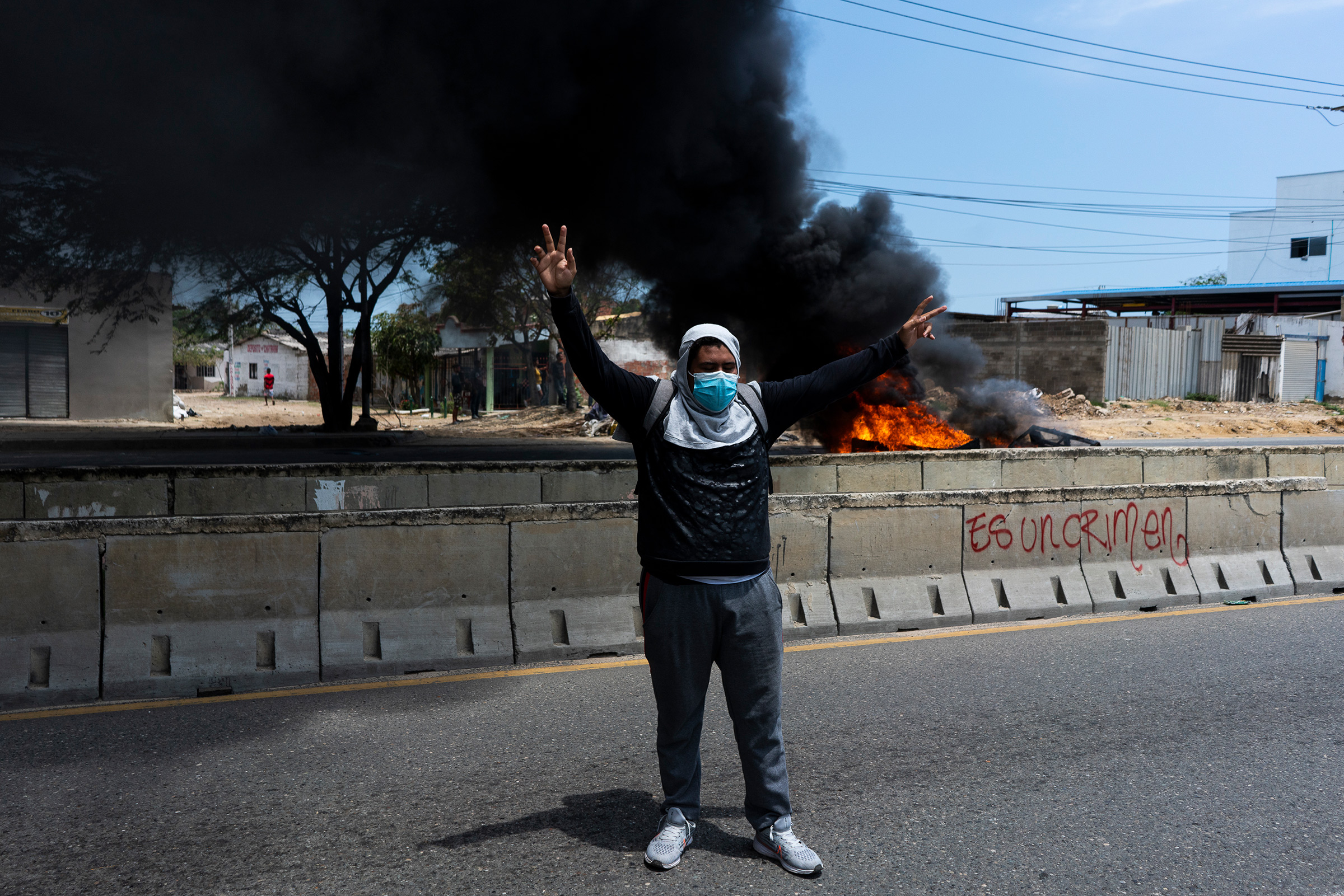 May 1, 2021 - Barranquilla, Colombia. A protester raises his hands in the midst of clashes with the police on Circunvalar Avenue Picture by: Charlie Cordero