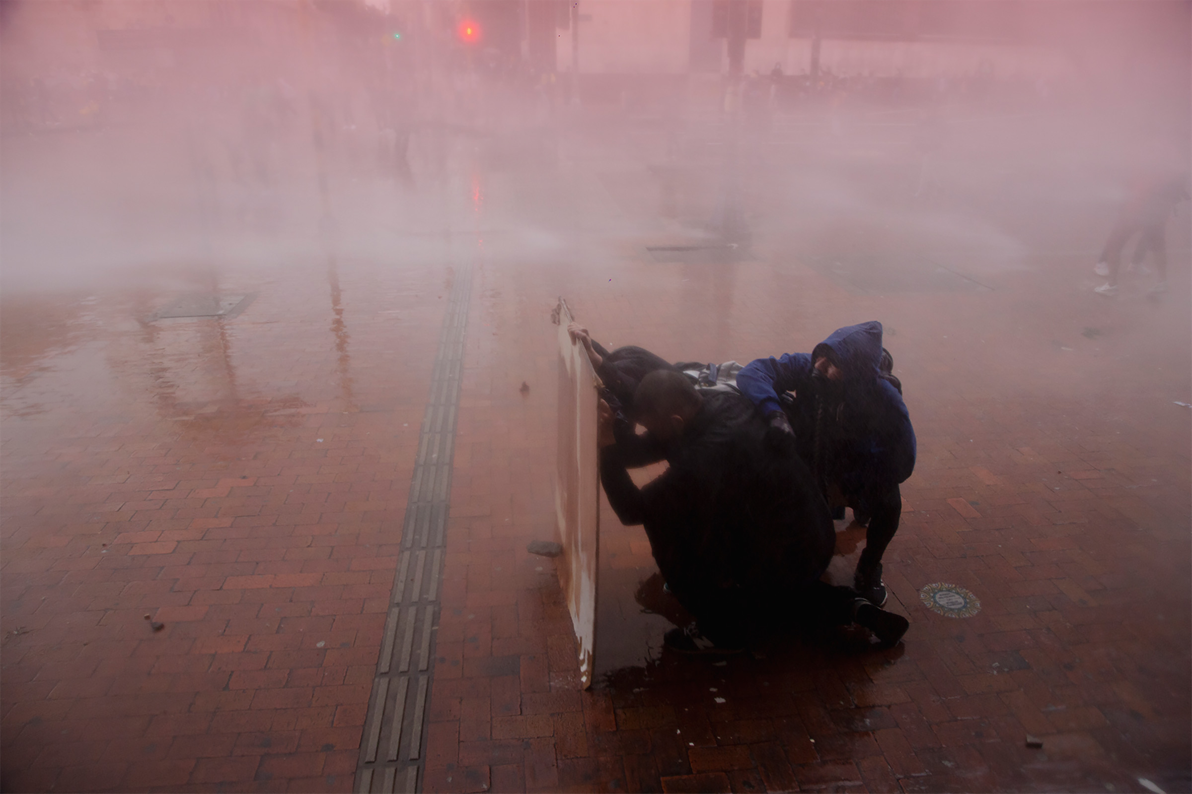 Riot police vehicles fire a water cannon to disperse the protesters in Bogotá on May 5. (Paula Thomas—Reojo Colectivo)