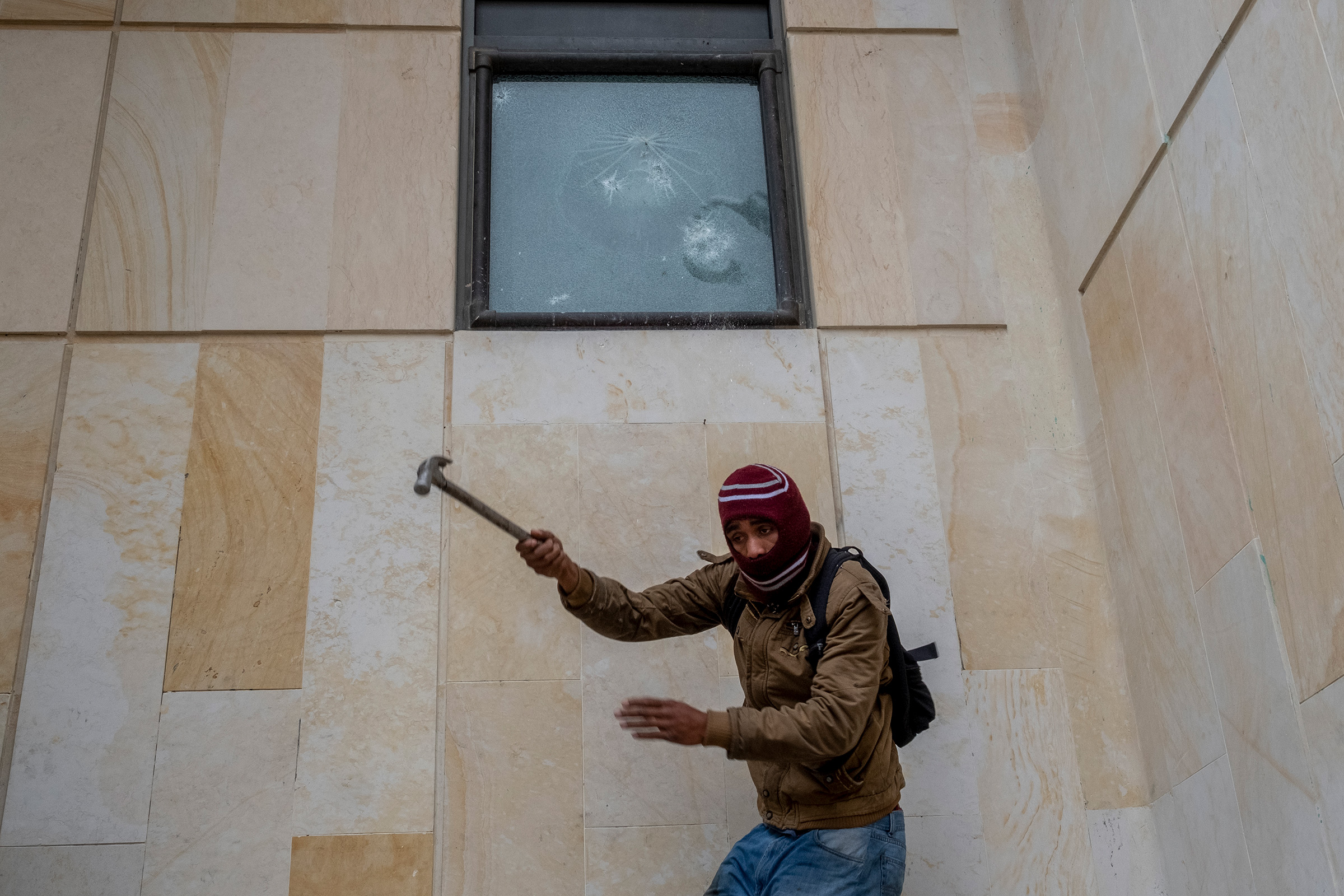 A protestor breaks a window at the Supreme Court Of Justice in downtown Bogotá on April 28. (Santiago Mesa—Reojo Colectivo)