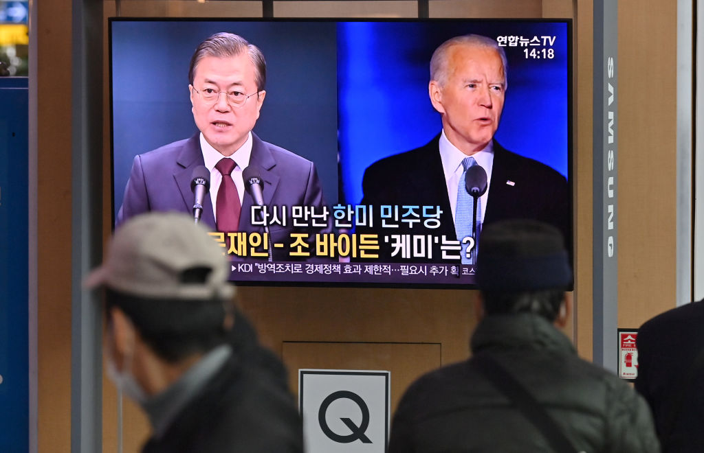 People watch a television news programme reporting on the US presidential election showing images of US President-elect Joe Biden (R) and South Korean President Moon Jae-in (L), at a railway station in Seoul on November 9, 2020. (JUNG YEON-JE/AFP via Getty Images)