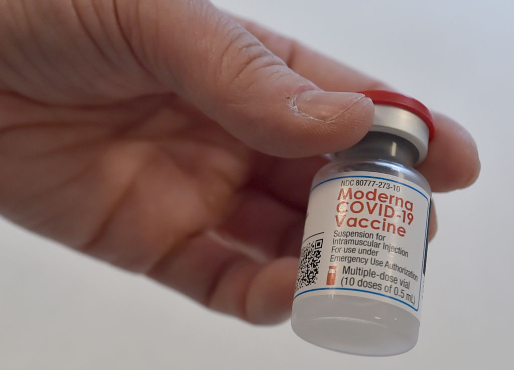 A health workers holds a vial of containing Moderna Covid-19