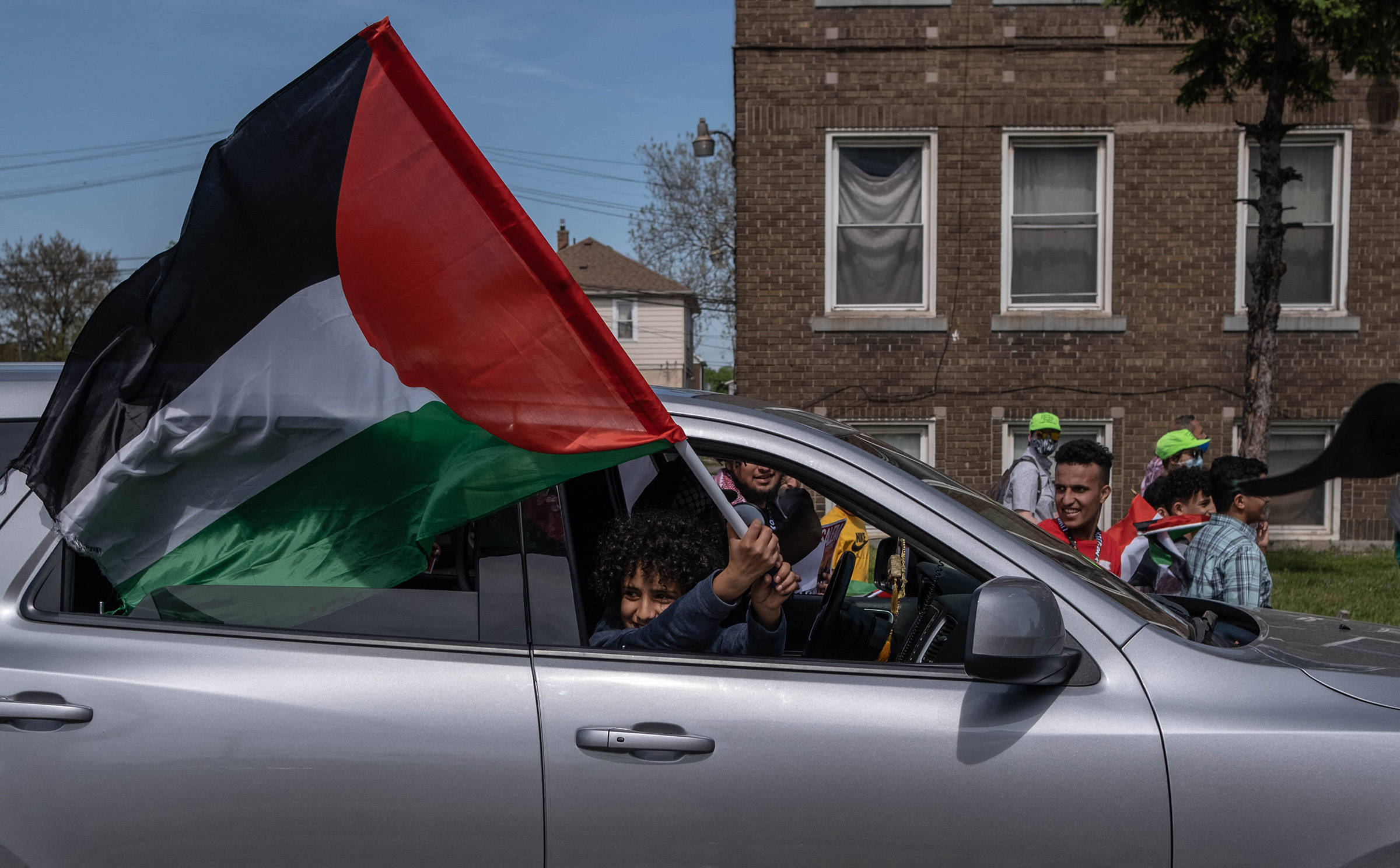 A protester waves a Palestinian flag during a march through neighborhoods near a Ford plant where U.S. President Joe Biden was touring in Dearborn, Mich., on May 18. (Seth Herald—AFP/Getty Images)
