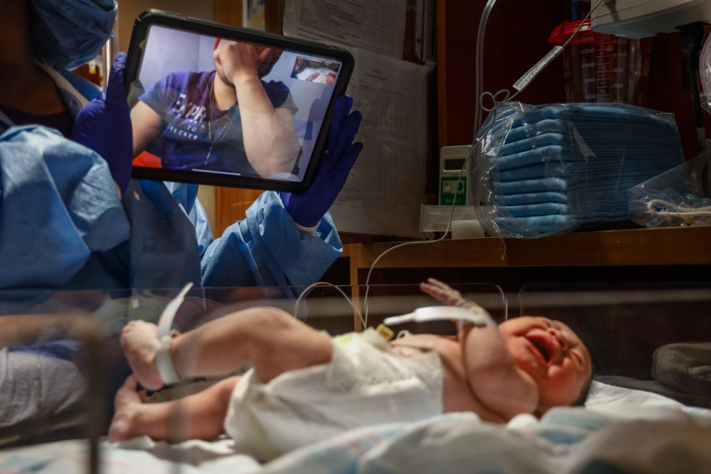 A man who tested positive for COVID-19 and was not permitted to attend the birth of his child on April 28, 2020, in Oceanside, N.Y., gets emotional seeing his newborn via FaceTime. (Jeffrey Basinger—Newsday/Getty Images)