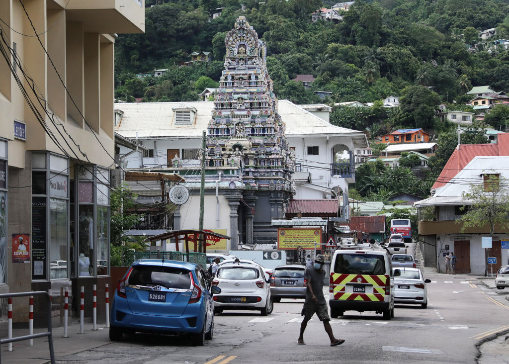 A man crosses a street in Victoria, the capital of the Seychelles in April 2021. The tiny Indian Ocean archipelago is seeing a spike in COVID-19 cases, despite having the highest percentage of people with two doses of vaccine of any country in the world. (Valery Sharifulin–TASS/Getty Images)