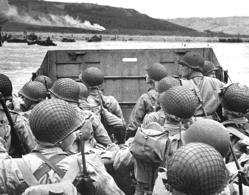 American shock troops huddle behind the protective front of a landing craft as it nears the beachhead on the Normandy coast of France