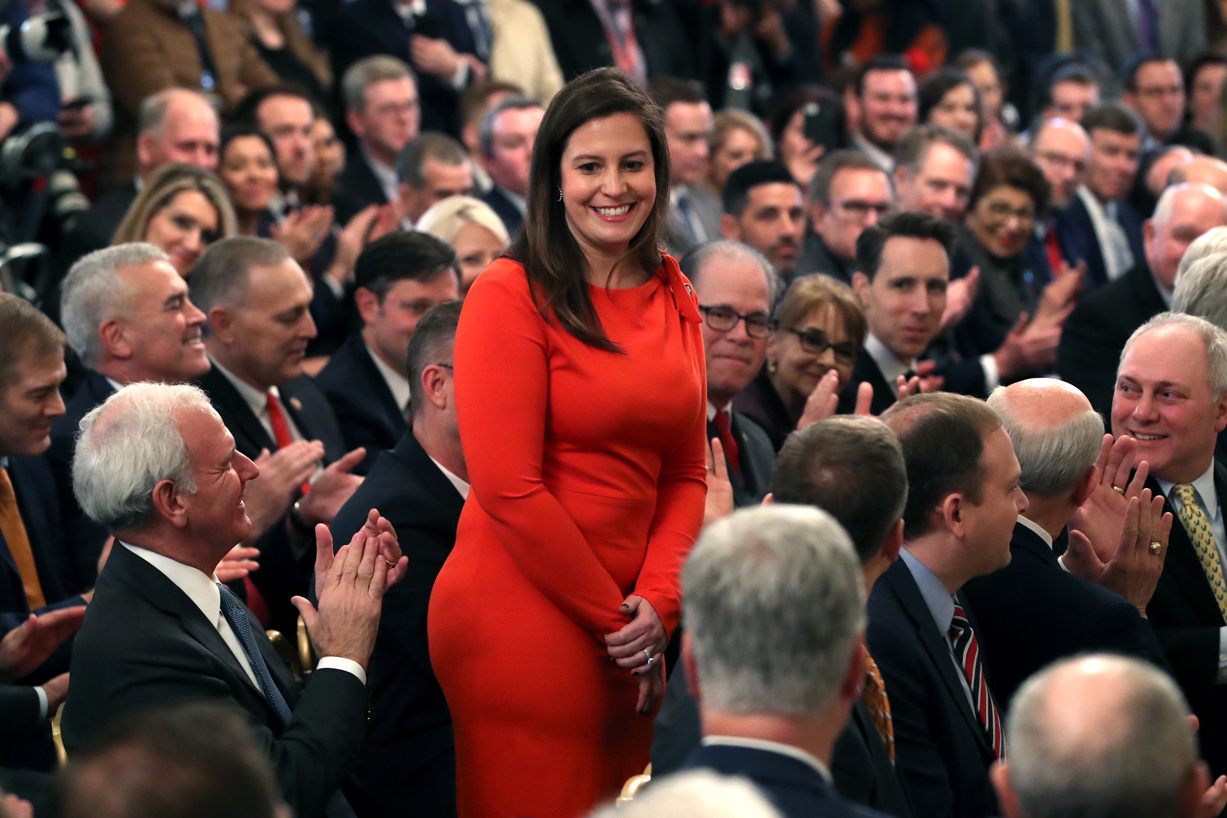 Elise Stefanik stands as she's acknowledged by former President Donald Trump as he speaks one day after the U.S. Senate acquitted on two articles of impeachment, in the East Room of the White House, Feb. 6, 2020