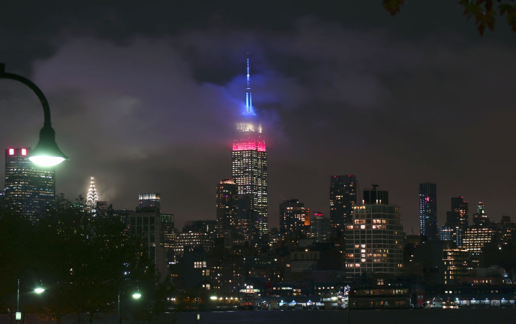 The Empire State Building glows in red, white, and blue in New York City